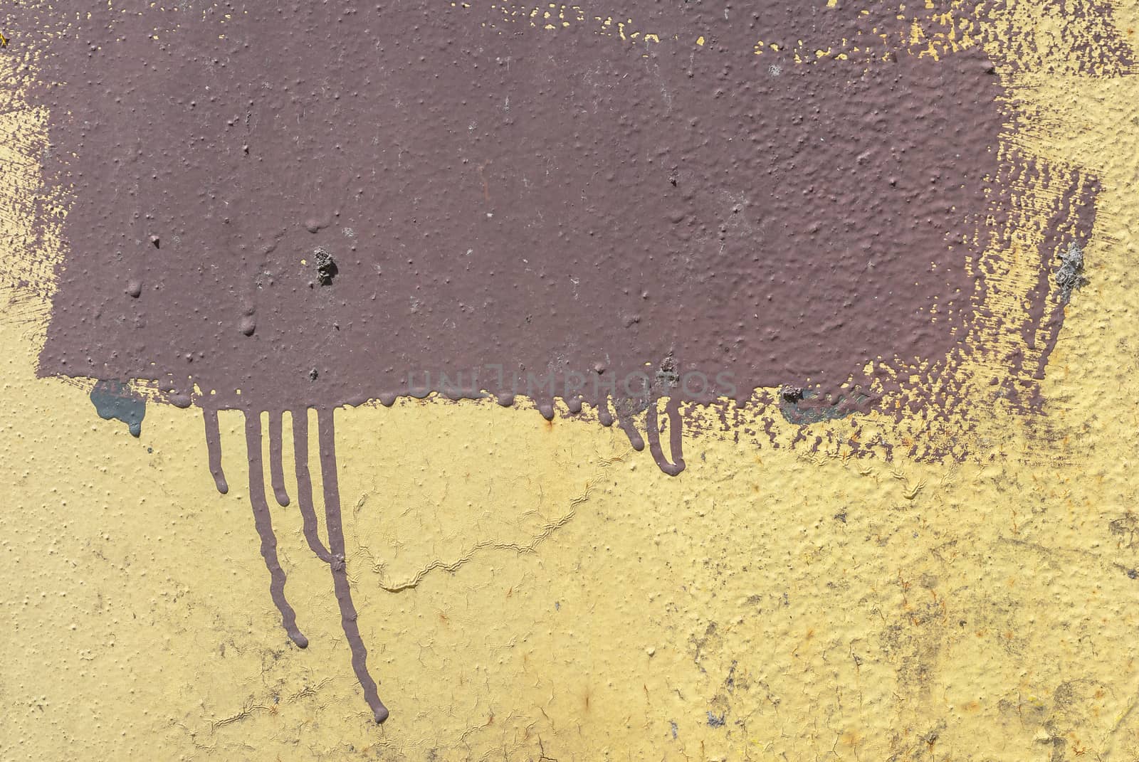 fragment of an iron surface is covered with brown and beige color paint, which has long been under the influence of different climatic conditions