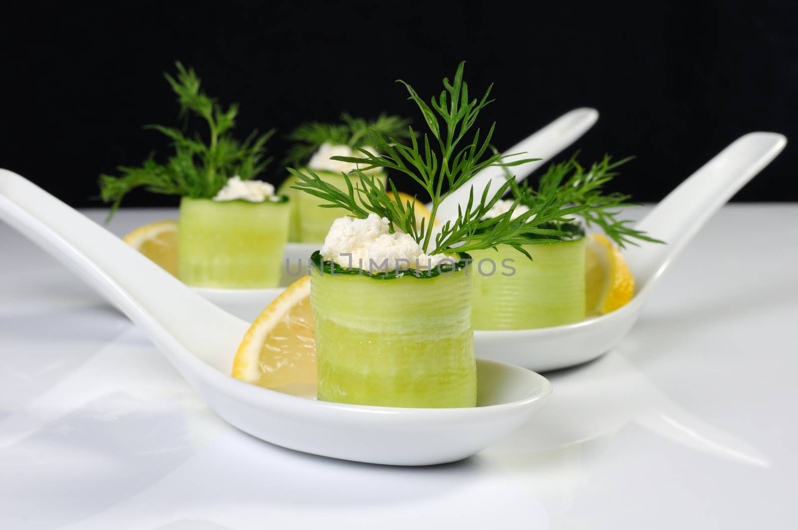 Cucumber canape with ricotta and lemon slice close-up. Horizontal shot. Foreground.