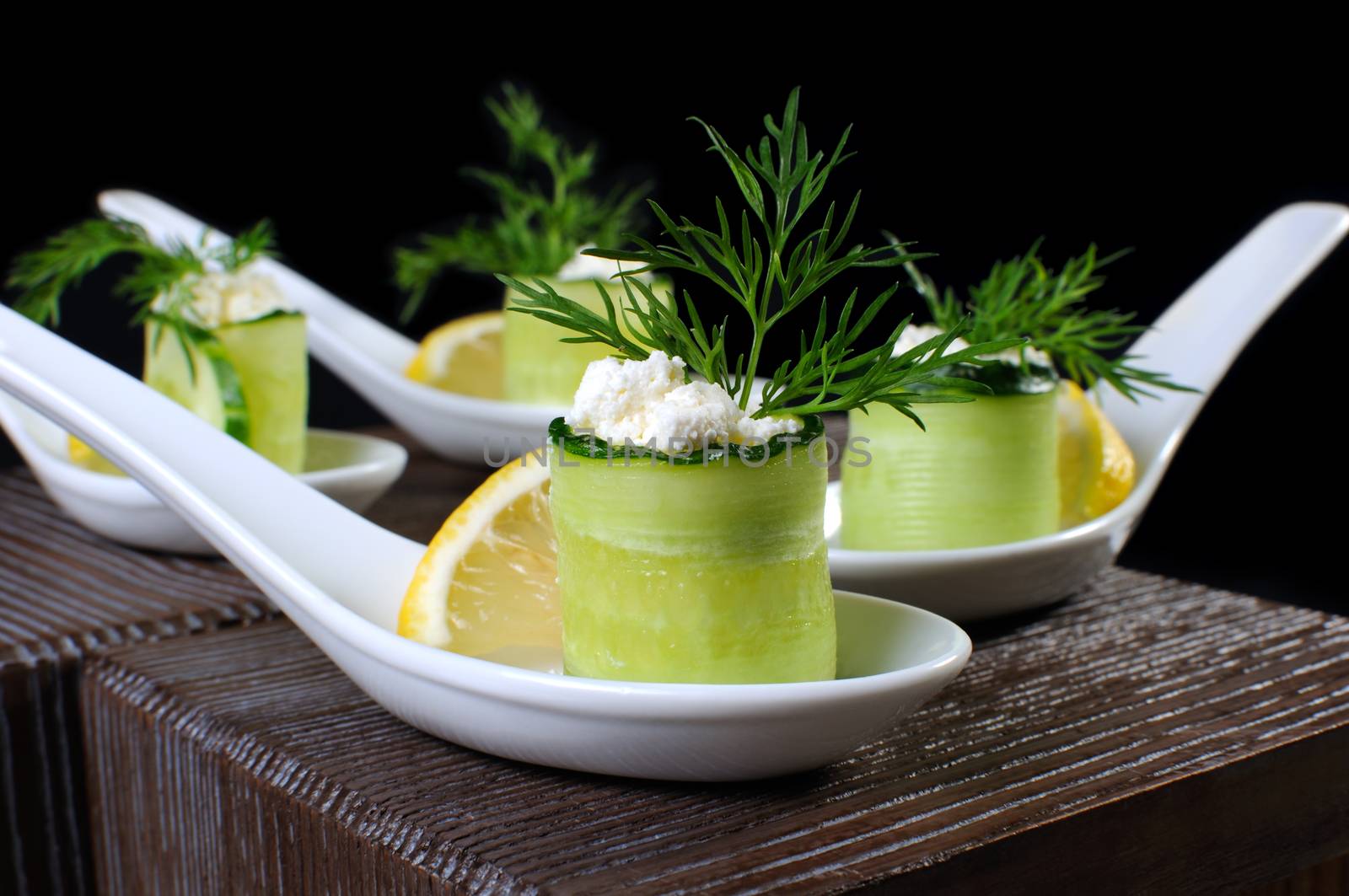 Cucumber canape with ricotta and lemon slice close-up. Horizontal shot. Foreground.