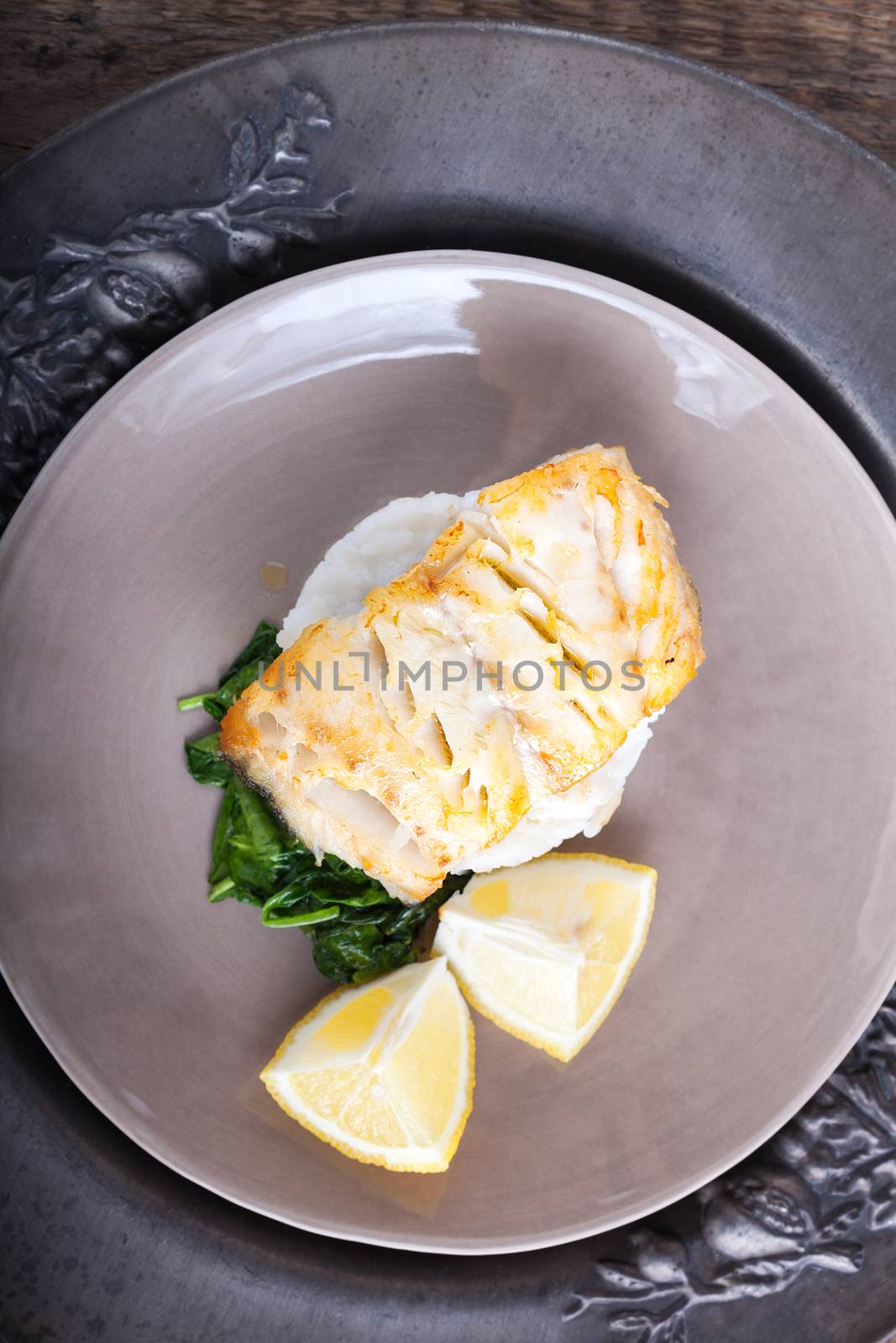 Fried cod fillets and spinach on the rice