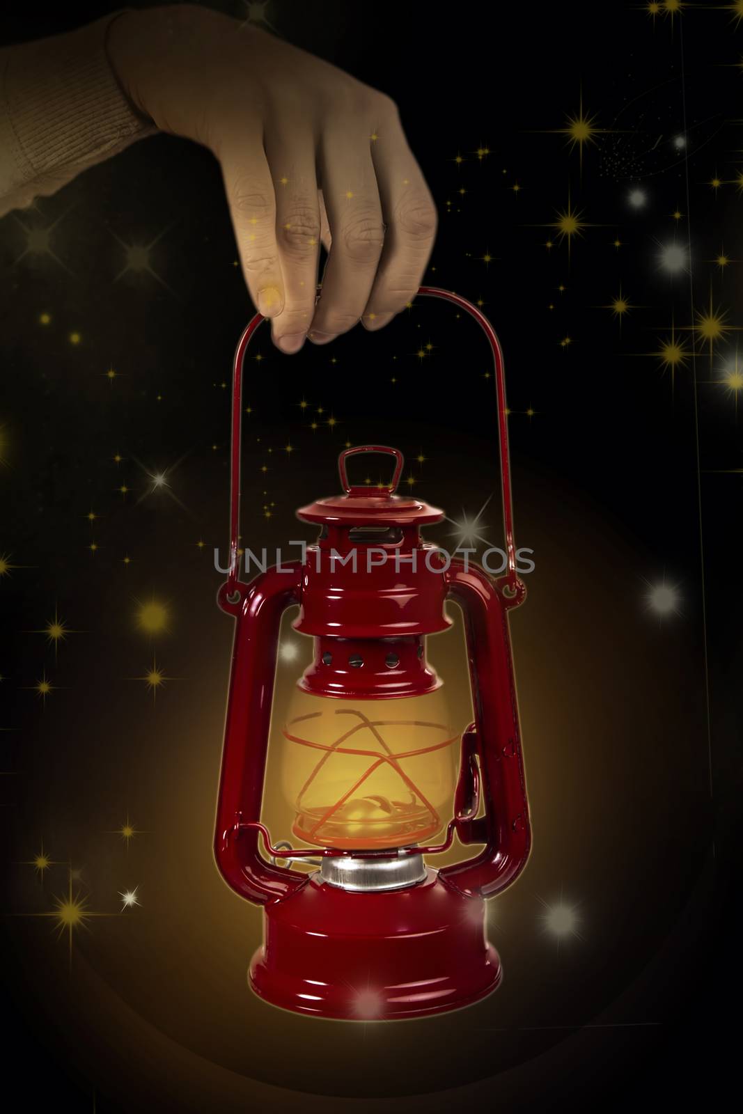 Old lamp with light in hand on a starry background