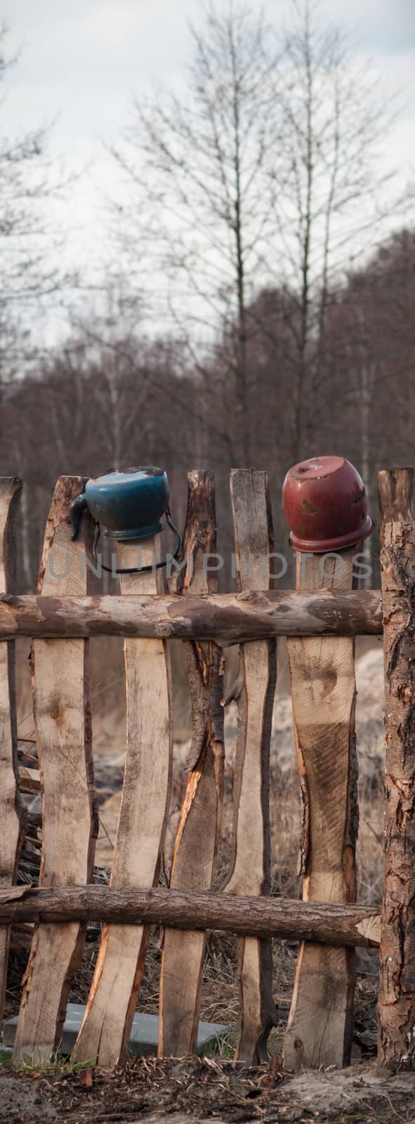 Old wooden boundary fence with nails on sunny day