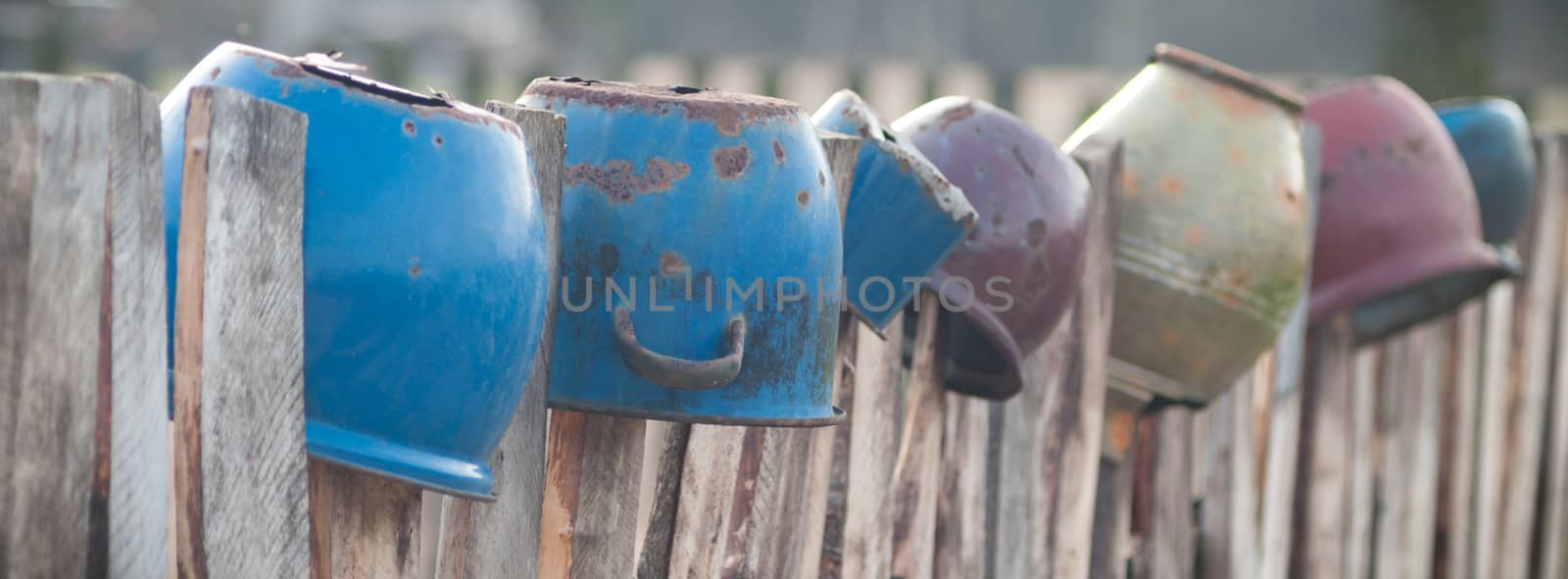 Old wooden boundary fence with nails on sunny day