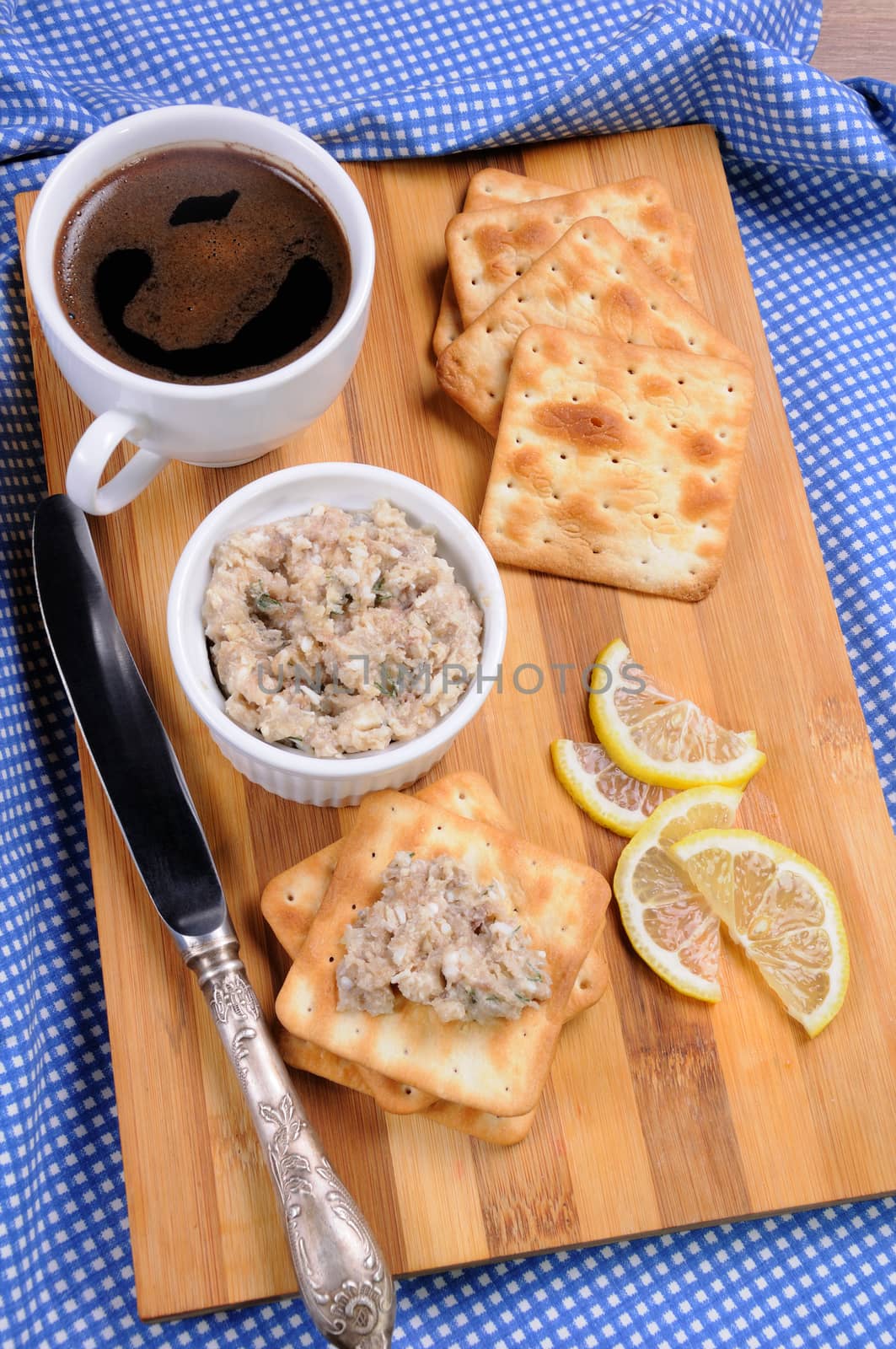 Appetizer of fish paste (forshmak) on a cracker with a cup of coffee