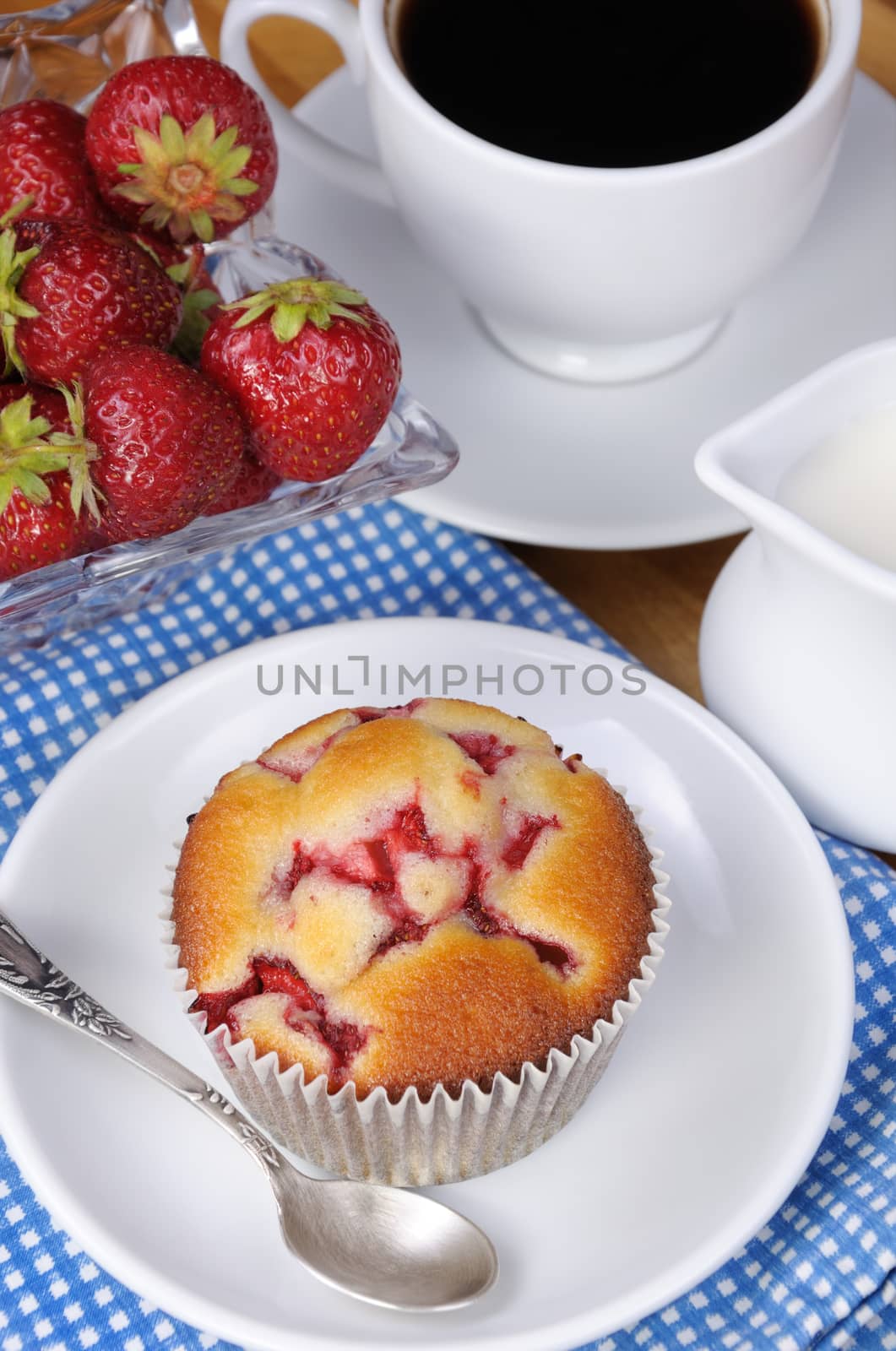 Muffin filled with strawberries on a table  cup of coffee