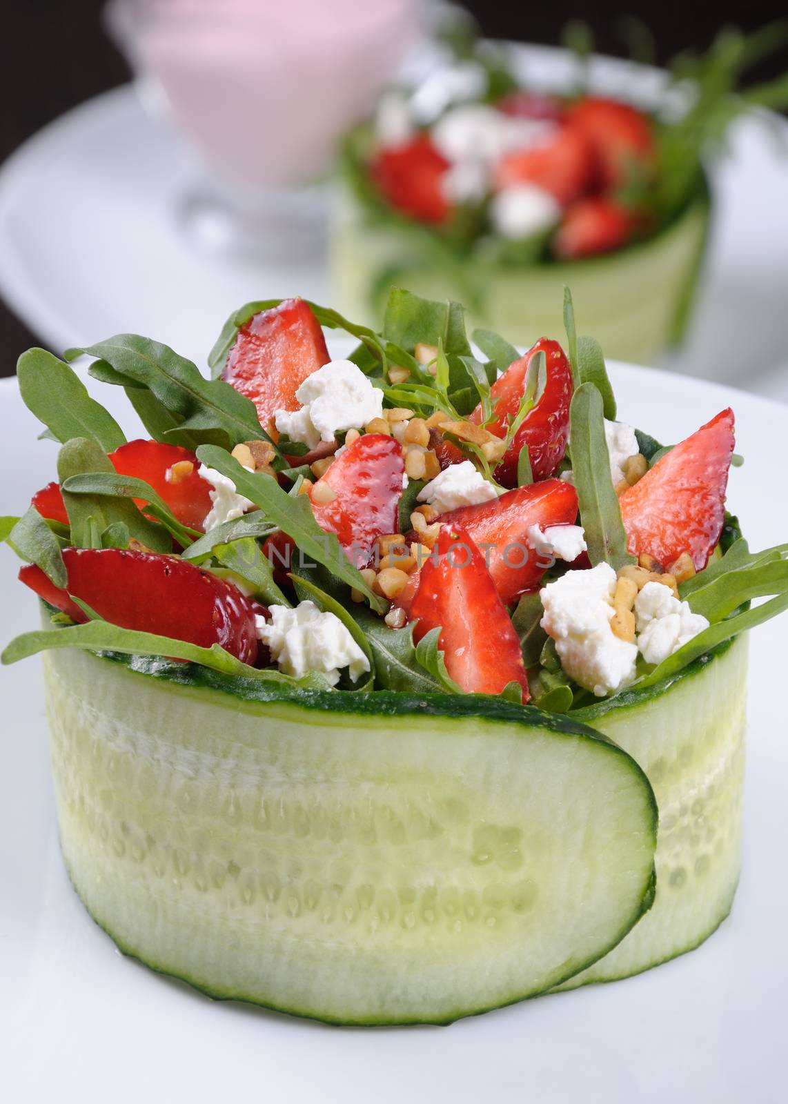 portion of strawberry salad with arugula and ricotta in cucumber