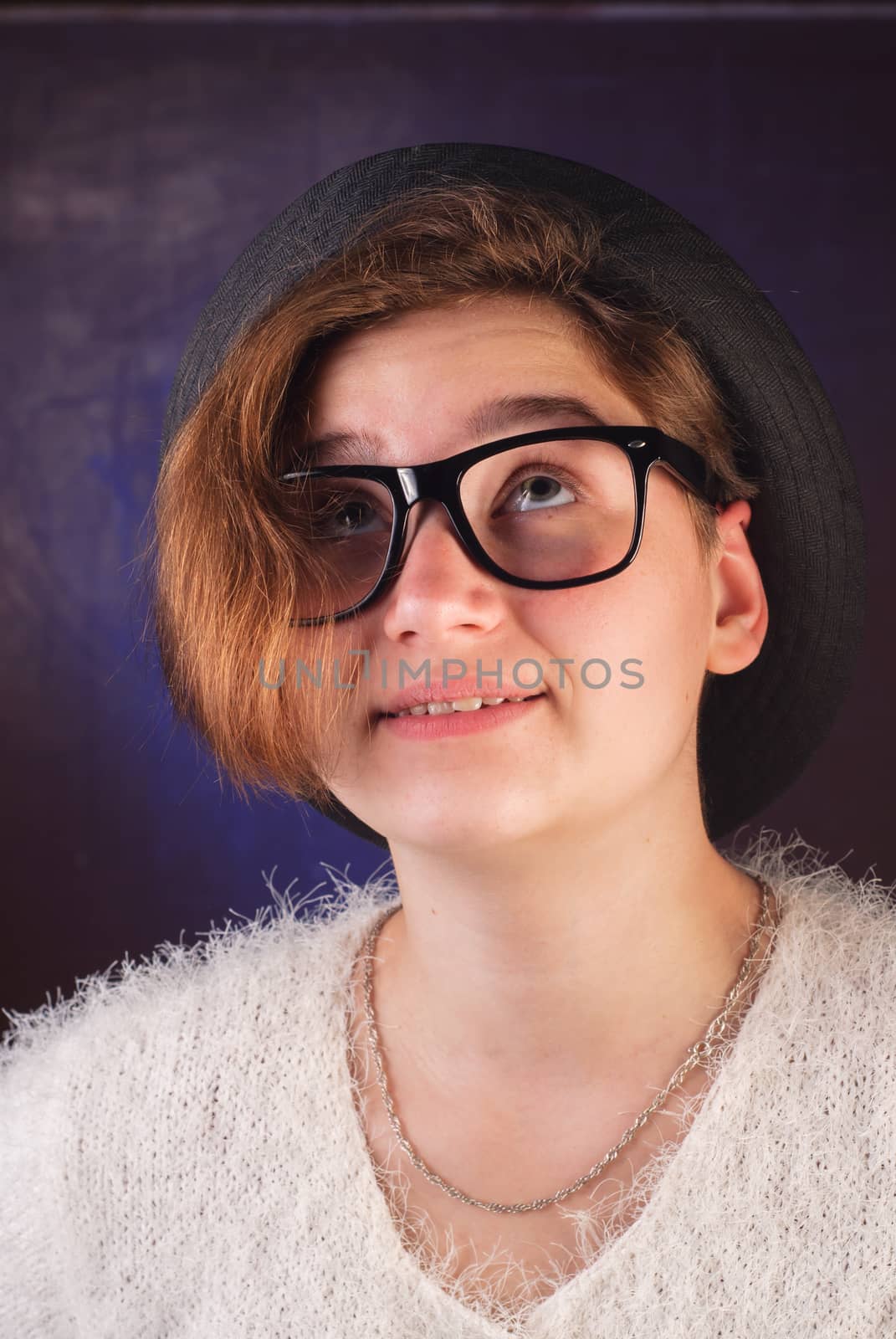 Young cute girl in a hat and sunglasses, a teenage girl posing for the camera, fashion accessories, hipster