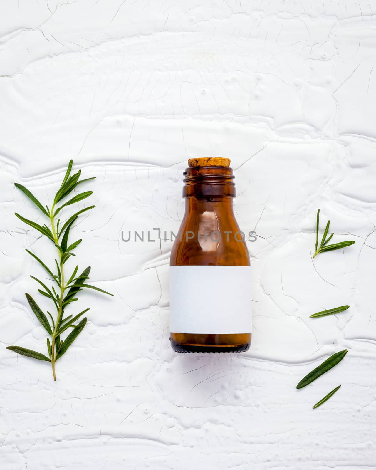 Fresh branch of rosemary  with bottle essential oil setup on whi by kerdkanno