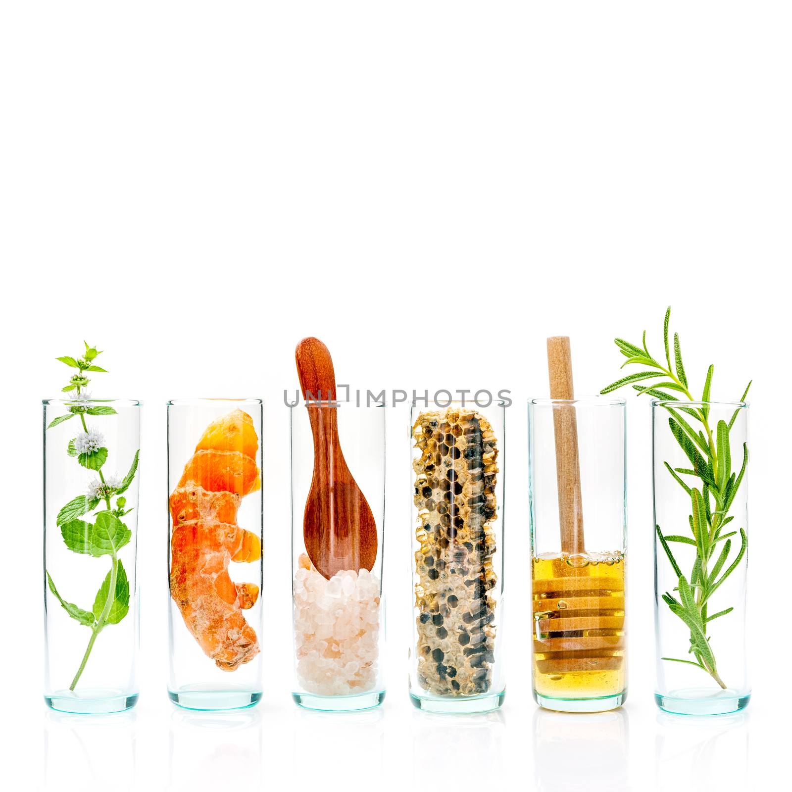 The glass bottle of homemade skin care and body scrubs with natural ingredients himalayan salt ,peppermint ,rosemary,turmeric and honey isolate on white background.