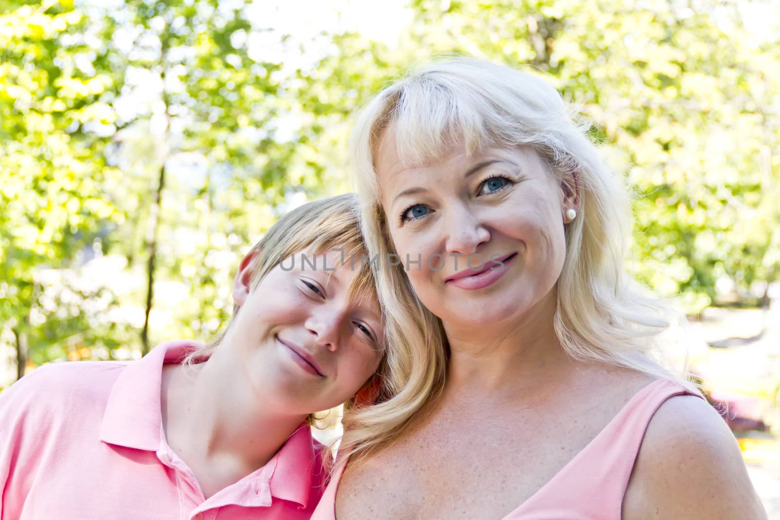 Portrait of woman with son in pink on green