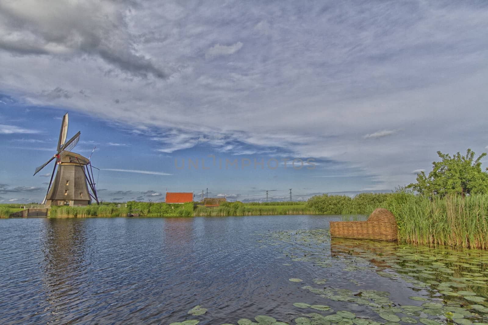 Windmill near the water canal in Netherlands by mariephotos