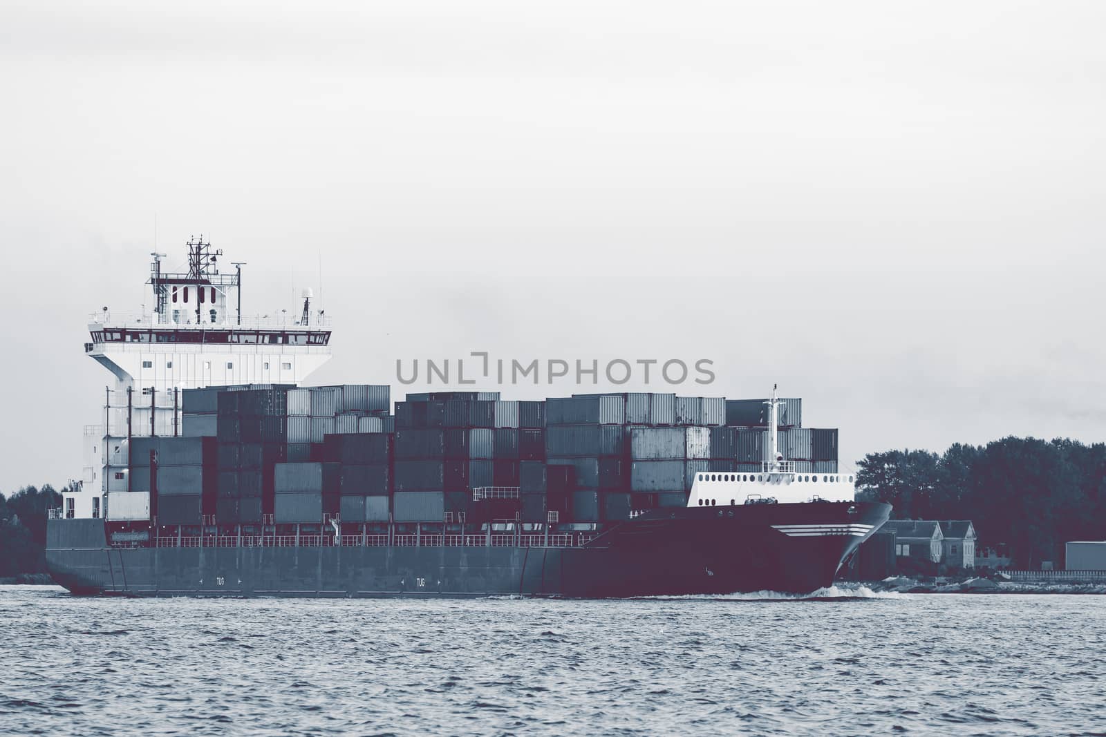 Full container ship moving to Baltic sea. Riga, Latvia