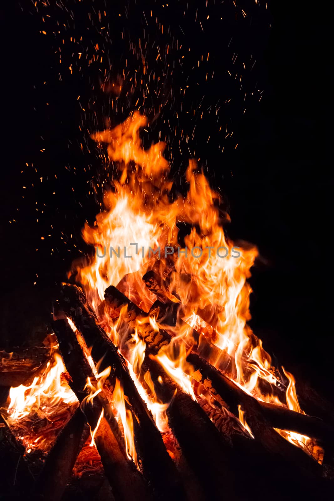 Campfire with flying sparks isolated on black background