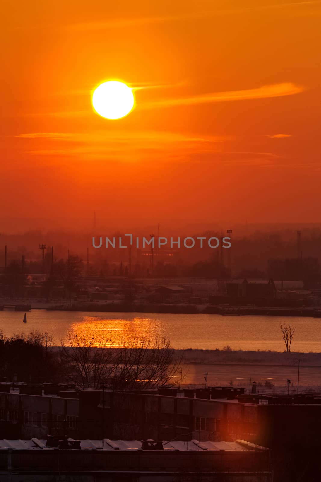 Hot orange sunset over the river. Urban landscape