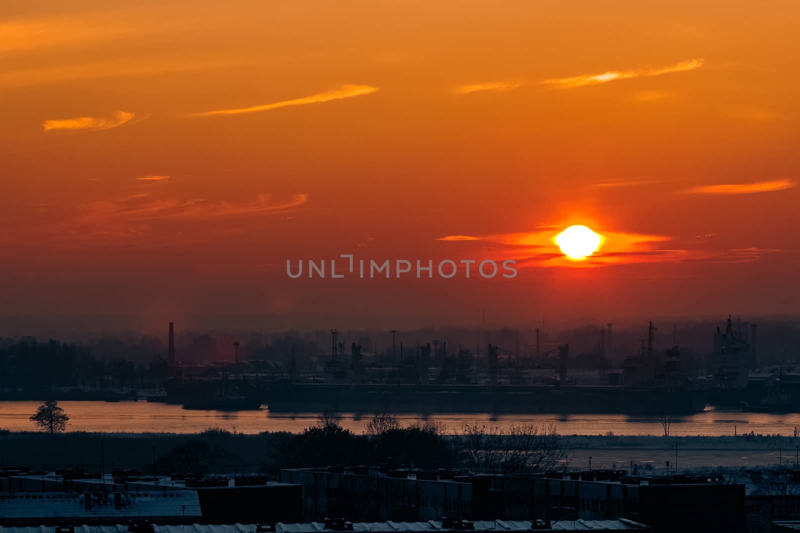 Hot orange sunset over the river. Urban landscape