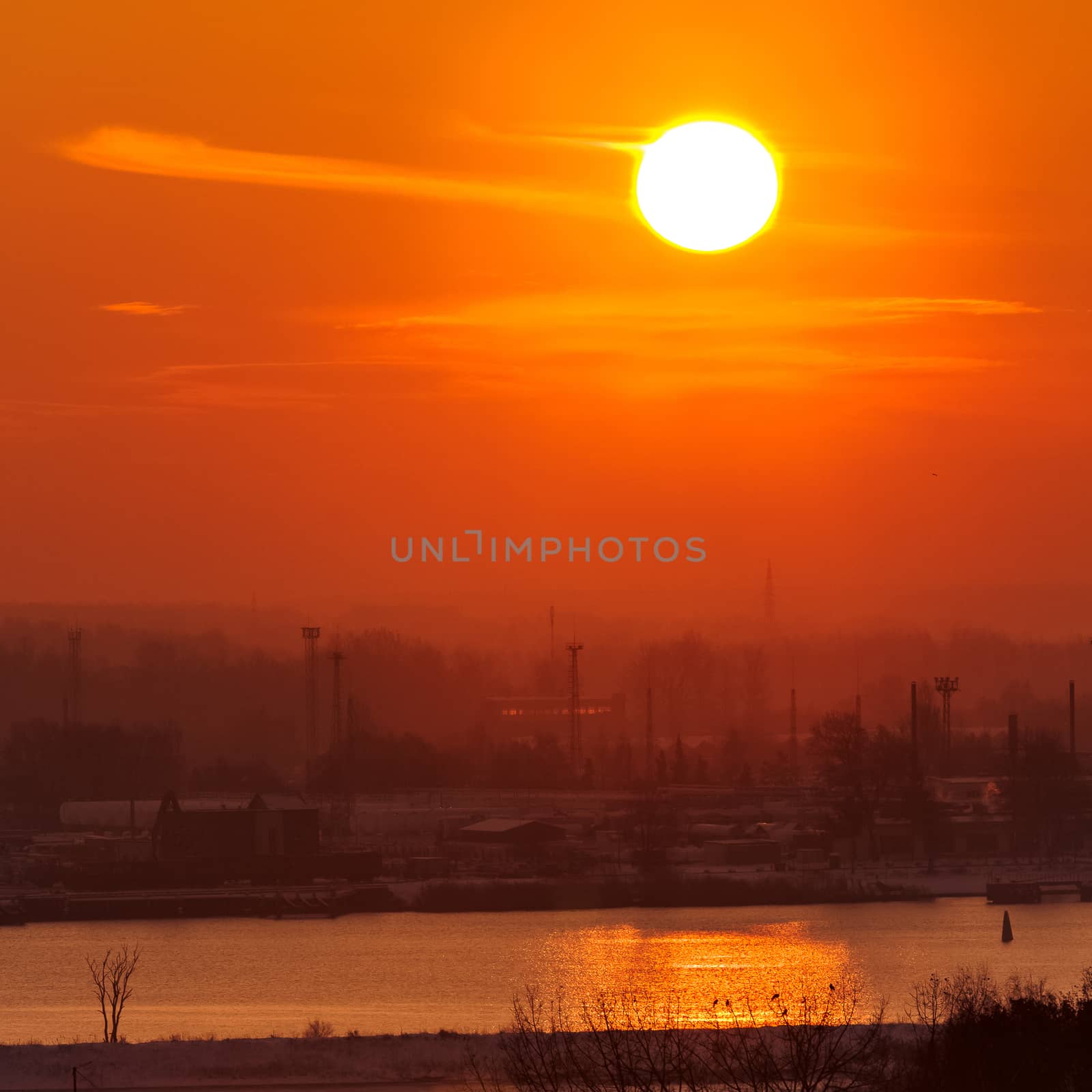 Hot orange sunset over the river. Urban landscape