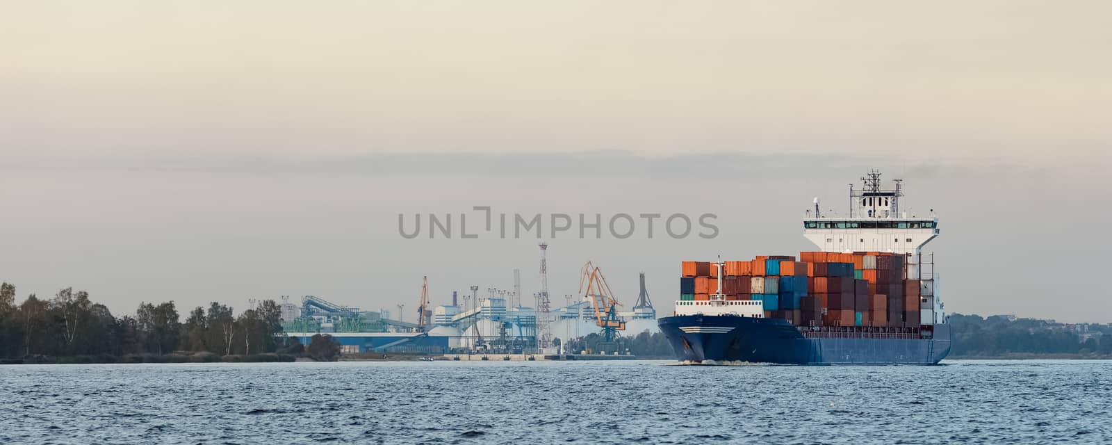 Blue container ship moving to Baltic sea. Riga, Latvia