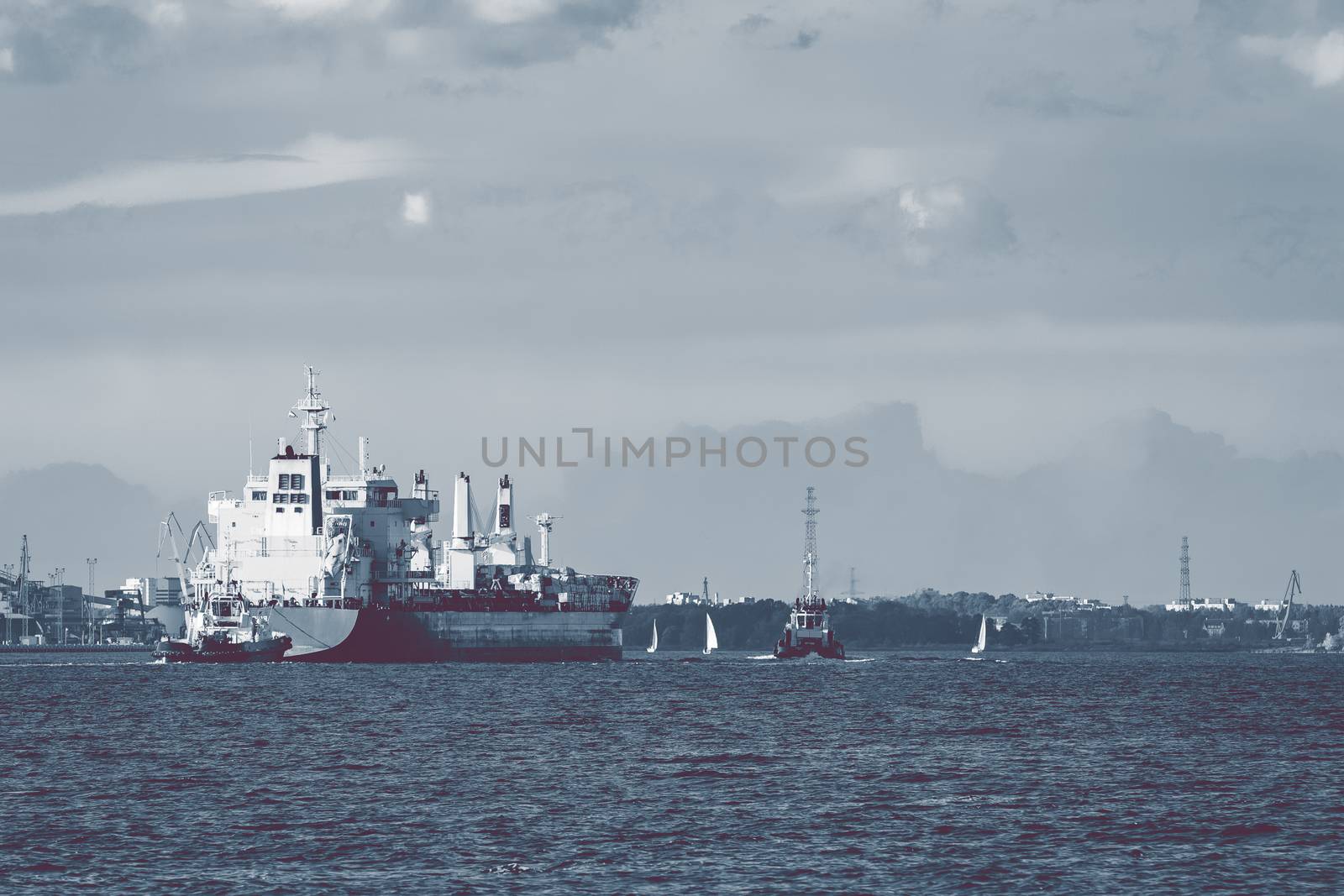 Cargo ship and the tug ship towing it to the port