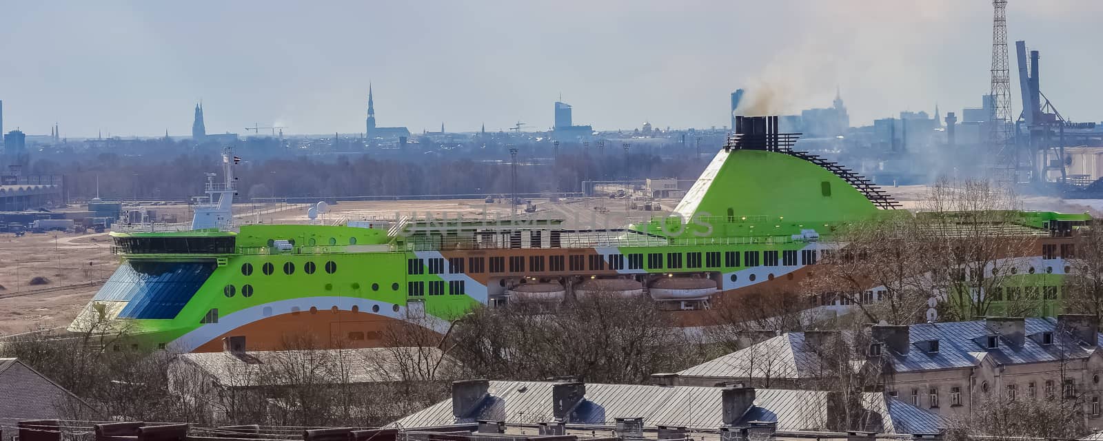 Green cruise liner. Passenger ferry sailing past the Riga city
