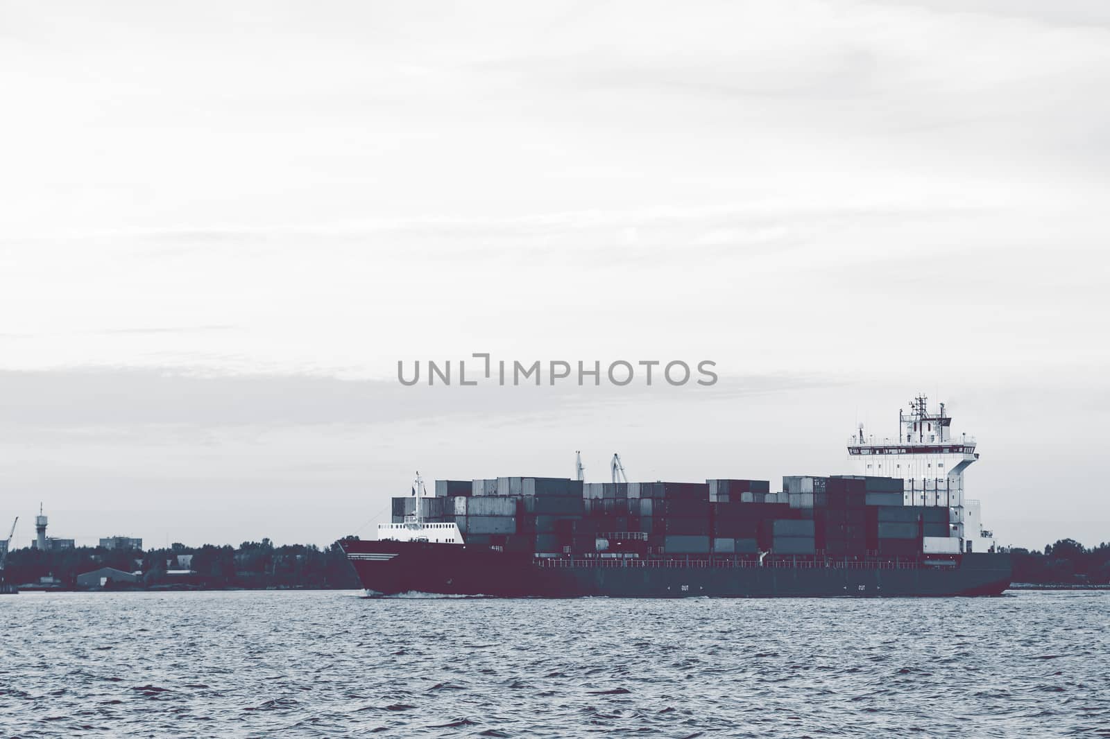 Full container ship moving to Baltic sea. Riga, Latvia