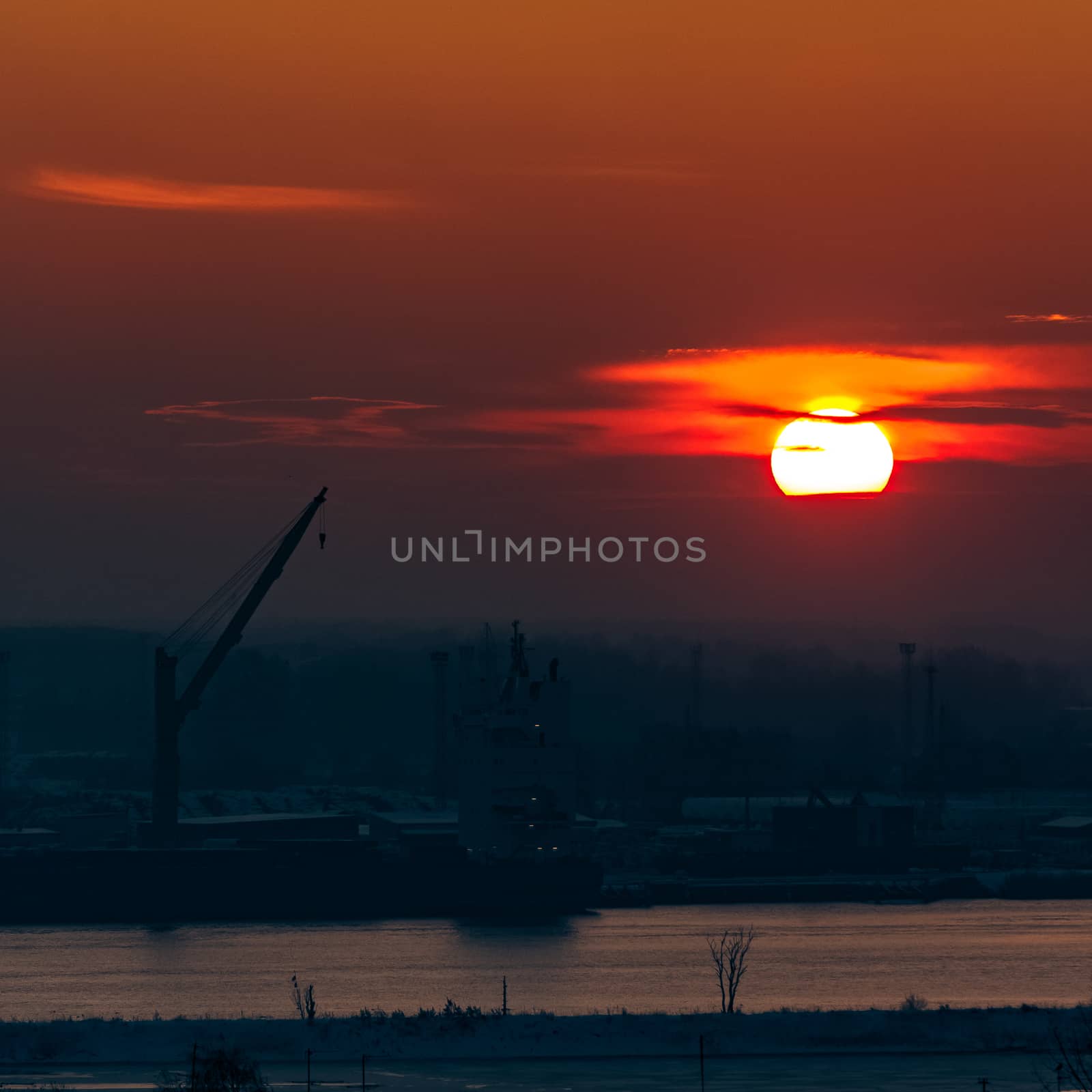 Hot orange sunset over the river. Urban landscape