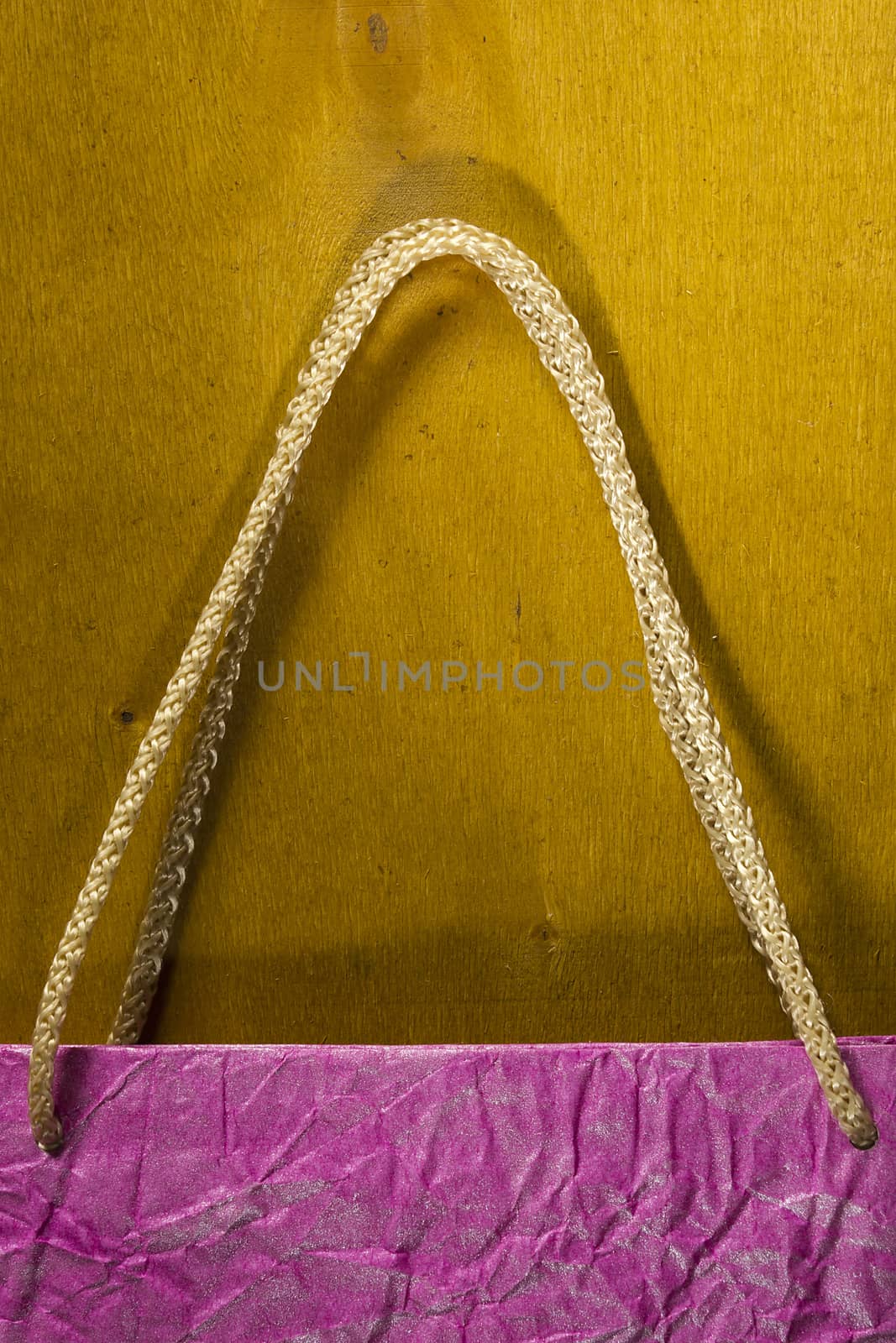 Rope handles from a paper bag on a wooden background