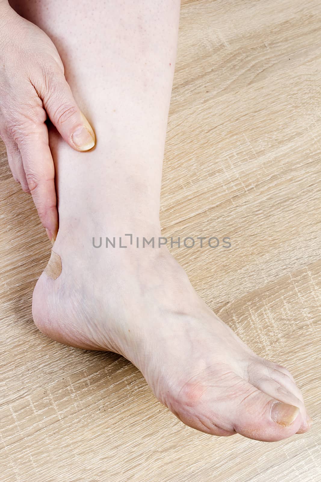 Female foot and hand close-up on a wooden background