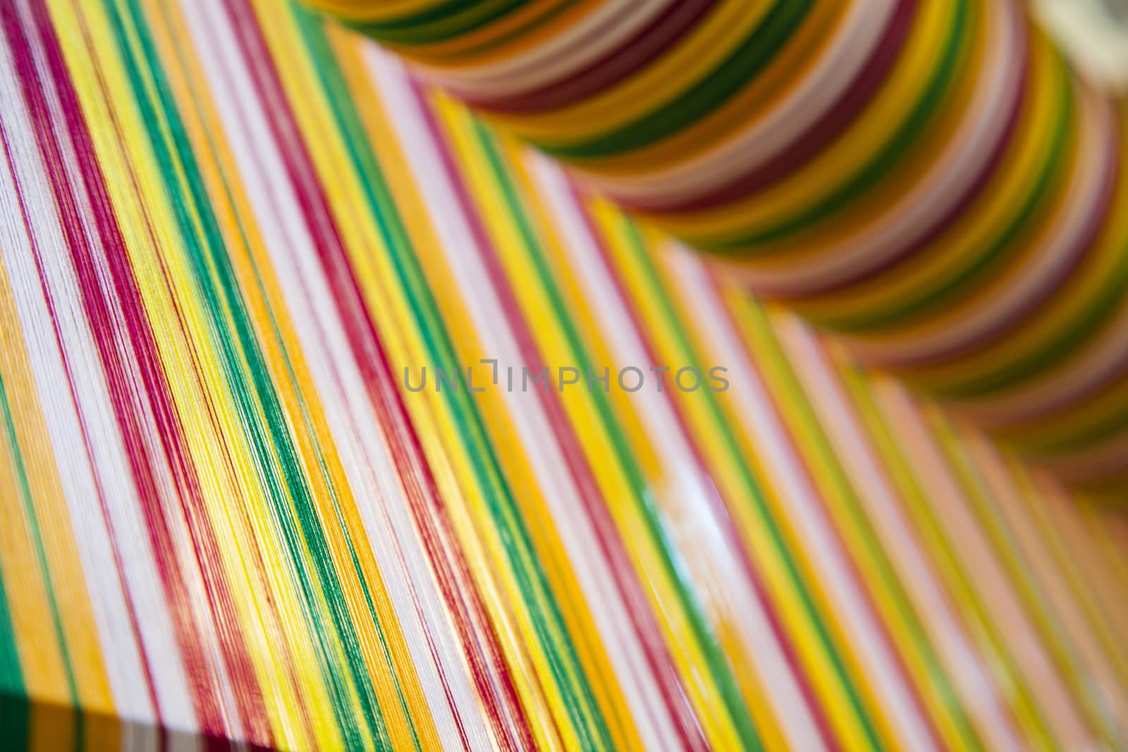 Yarn background, old weaving Loom and thread of yarn. A traditional hand-weaving loom being used to make cloth at home.Background surface blurred.