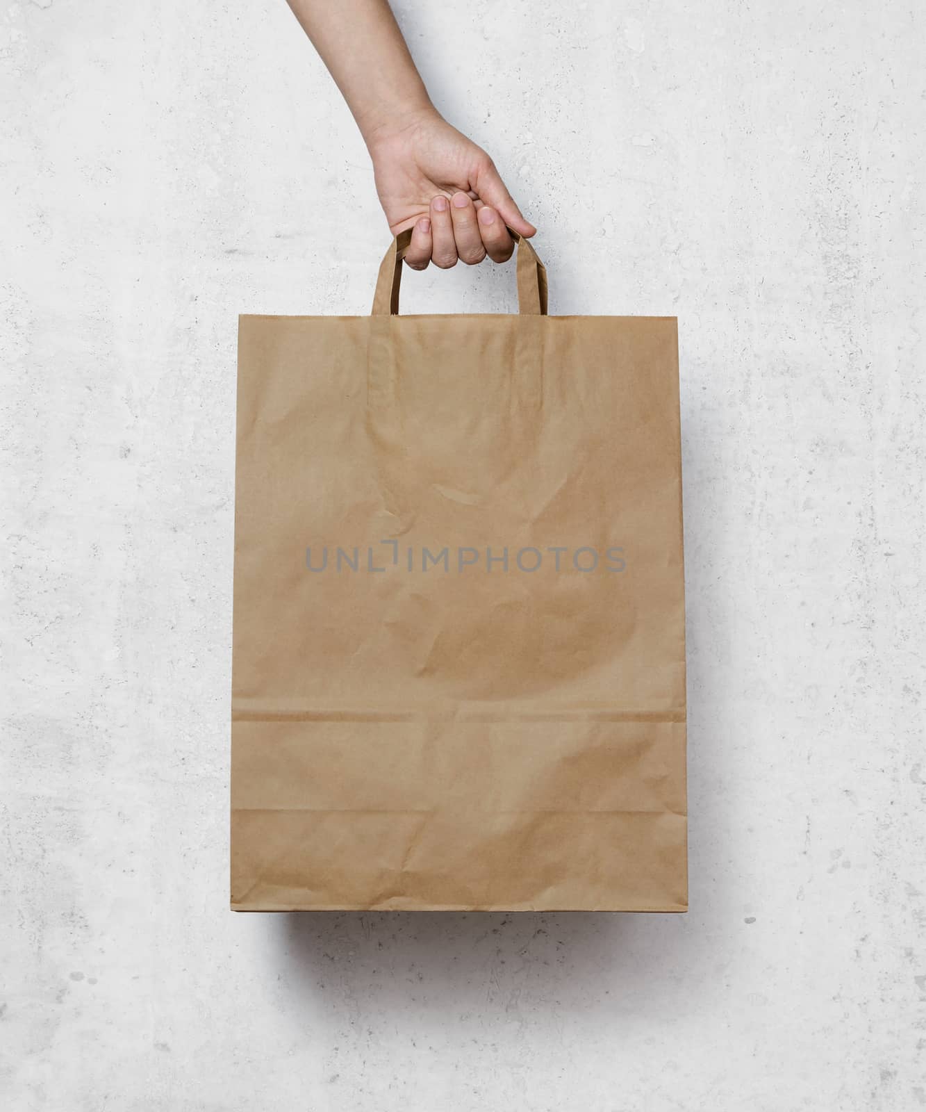 human hand carry blank slate beige paper bag