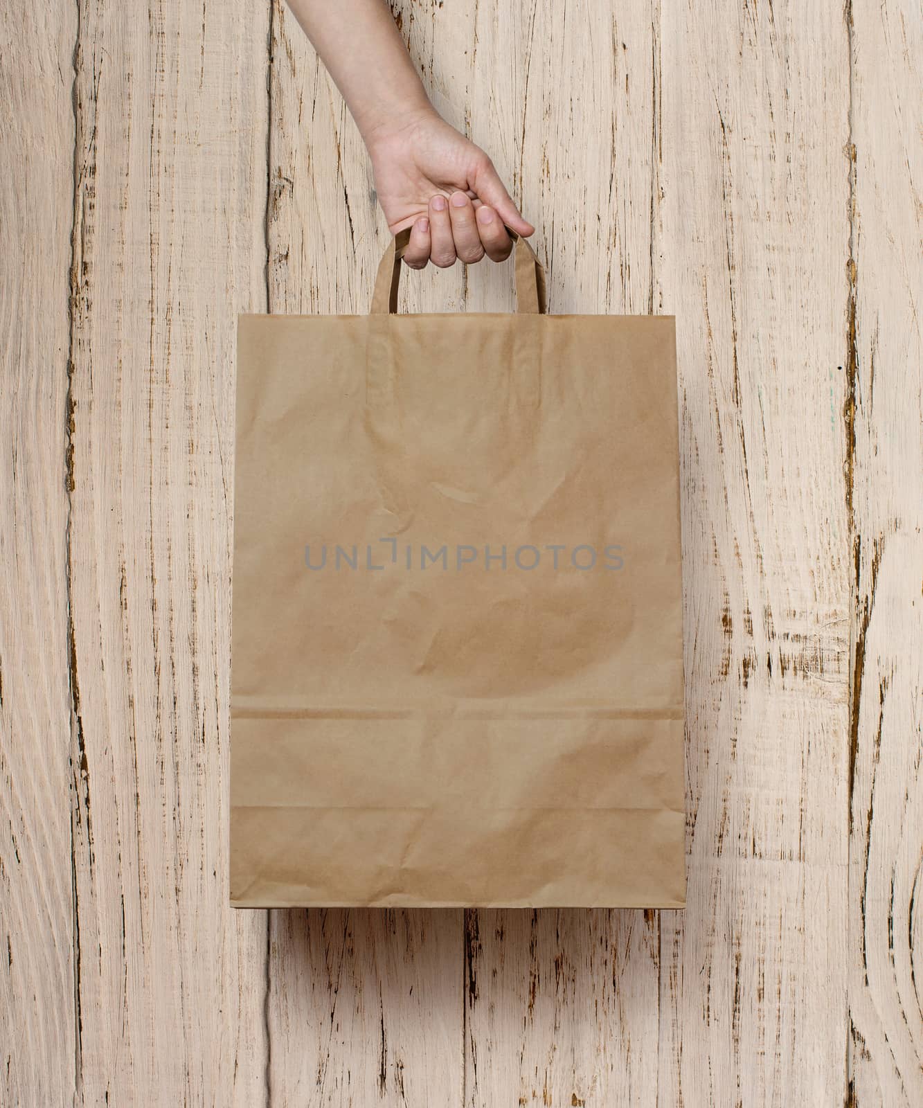 human hand carry blank slate beige paper bag