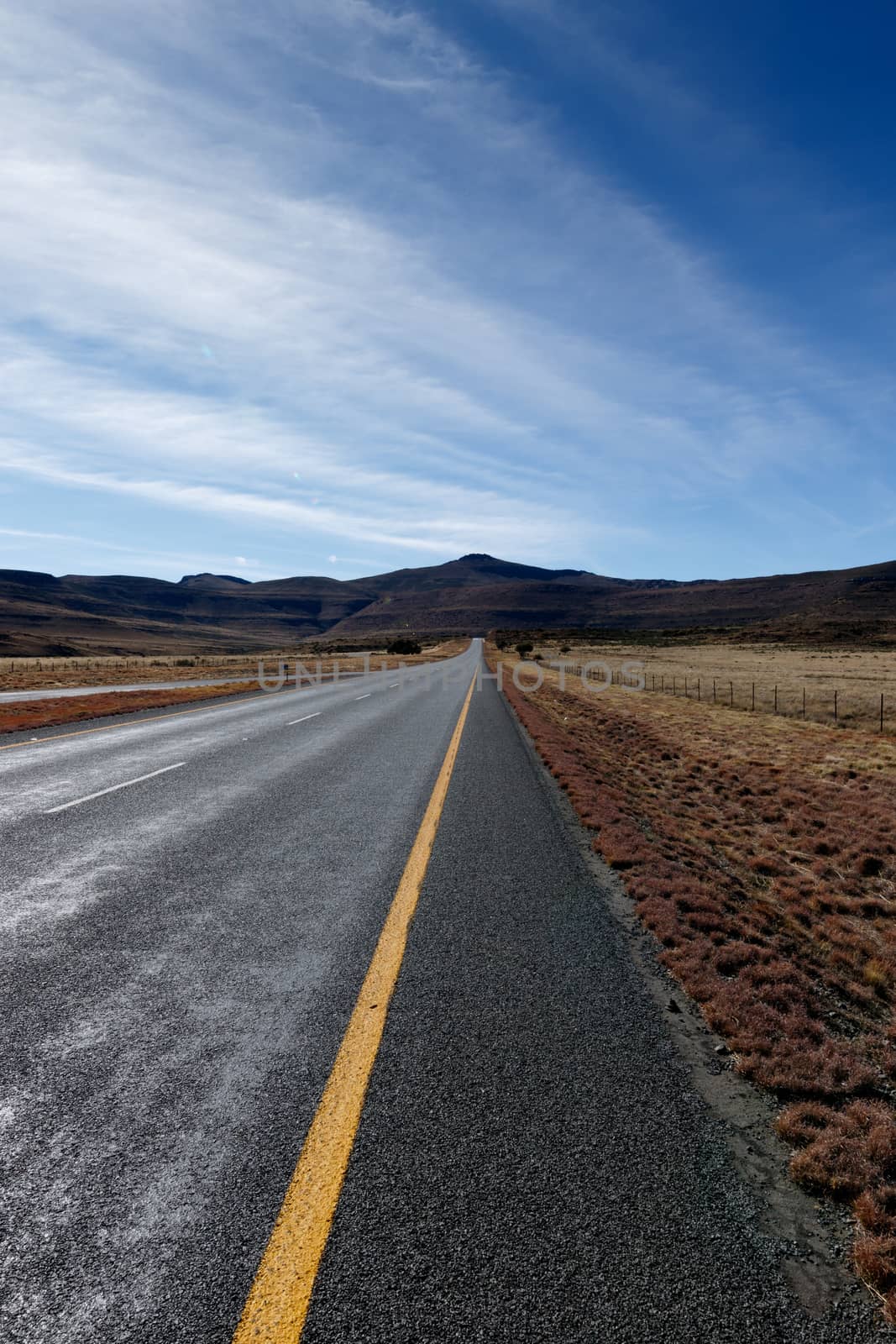 The long road leading to the mountains with blue skies in Graaff-Reinet.