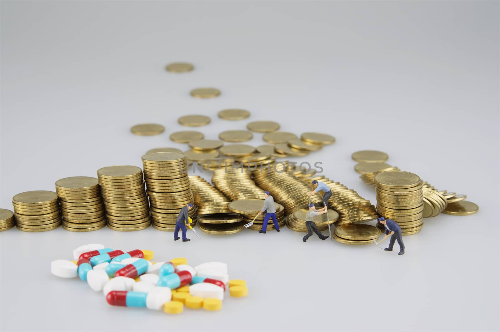 Stack of gold coin with miniature people and blur medicine by ninun