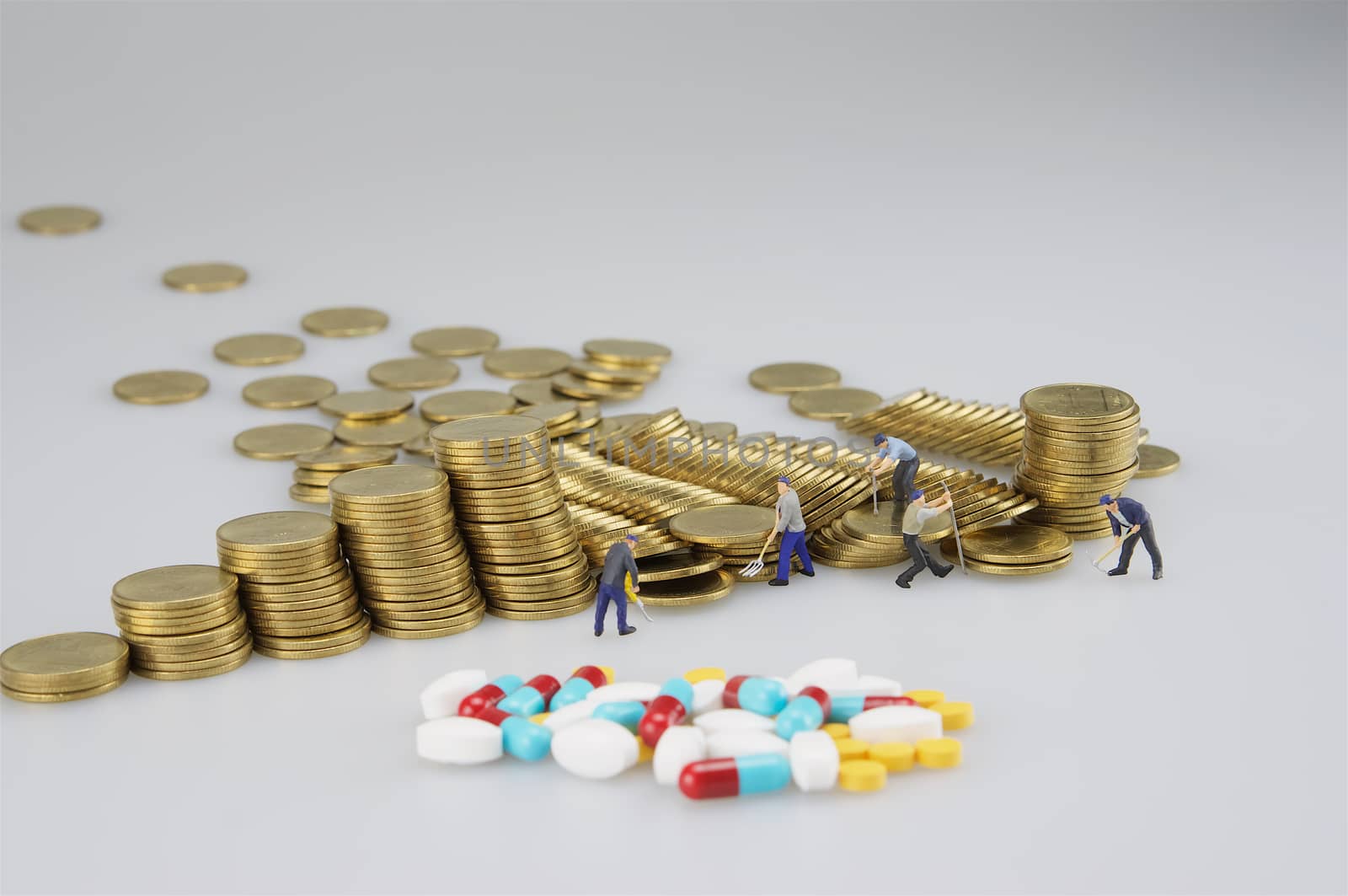 Stack of gold coin with miniature people and medicine by ninun