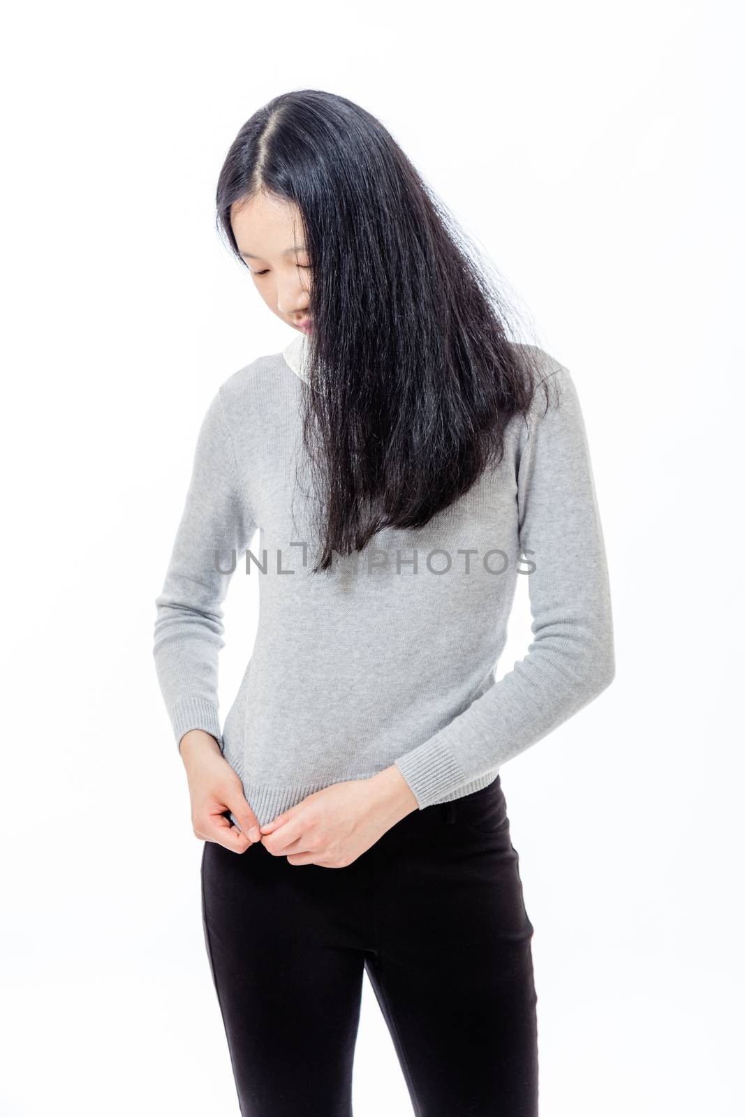 Timid nervous Asian  teenage girl looking down holding sweater