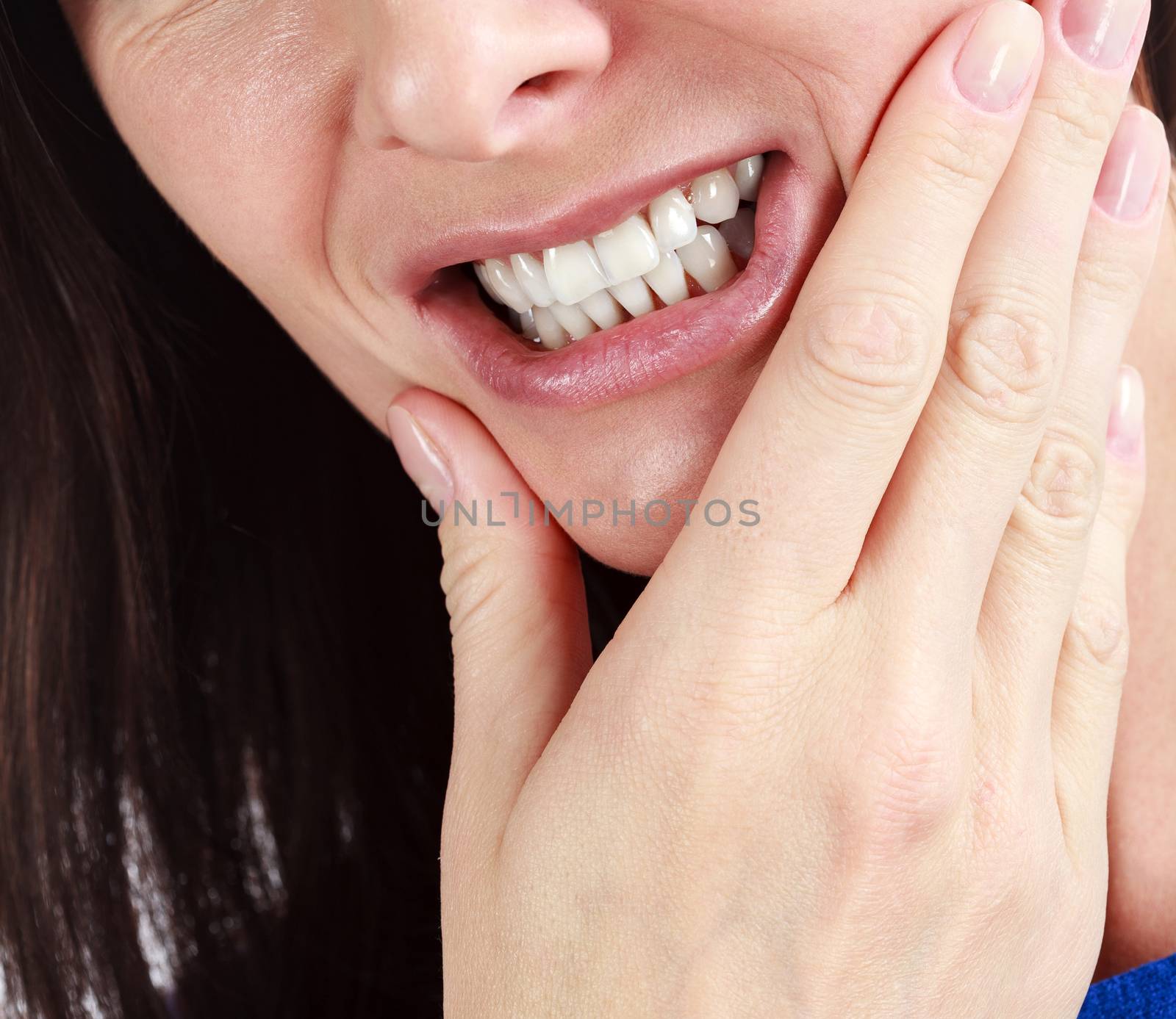 Closeup of woman in strong toothache pain with hands over face. Dental health and care concept.