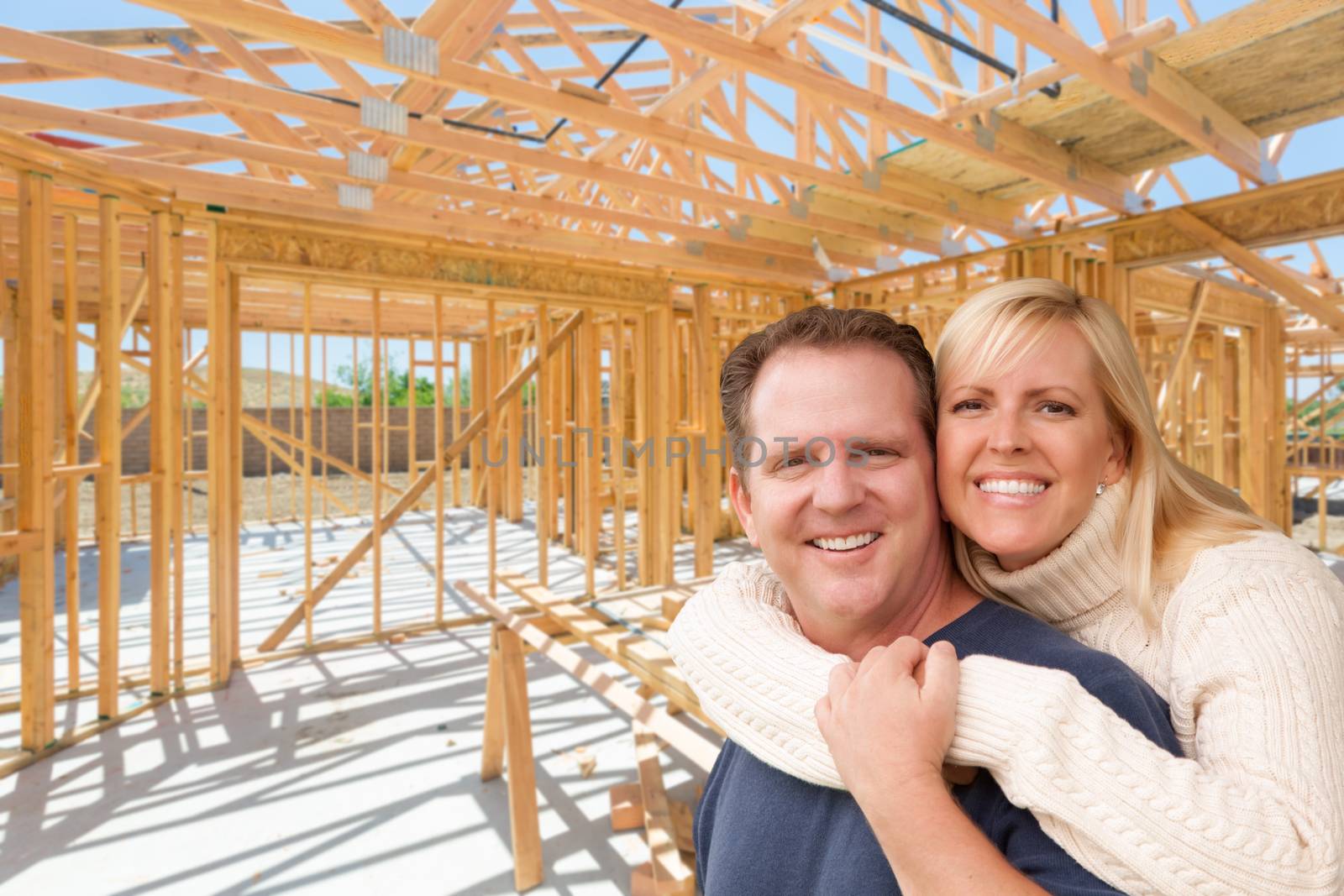 Happy Excited Couple On Site Inside Their New Home Construction Framing.