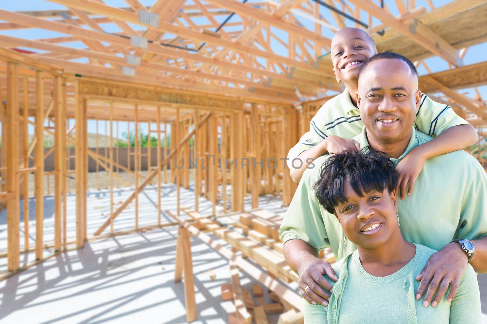Young African American Family On Site Inside Their New Home Construction Framing.