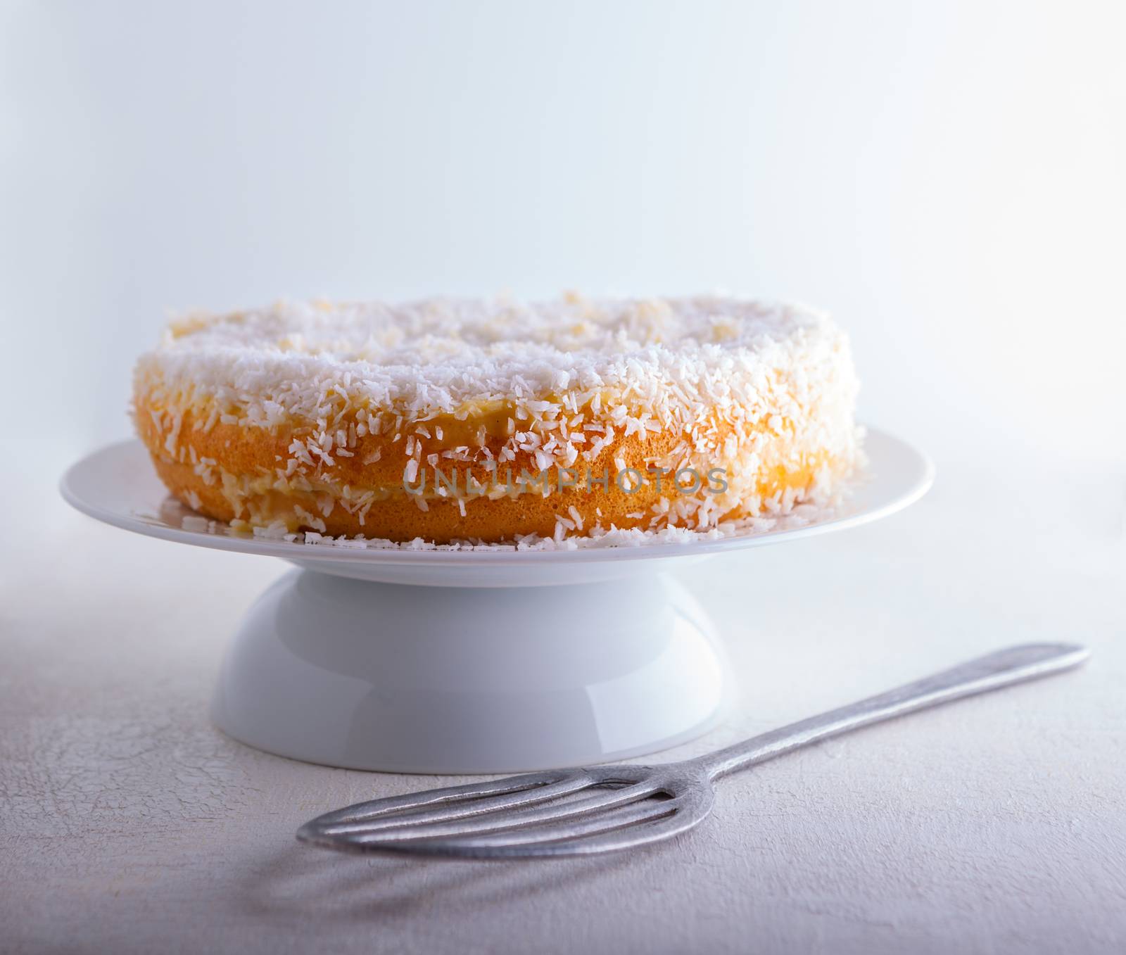 Slice of Homemade coconut cake on a white background