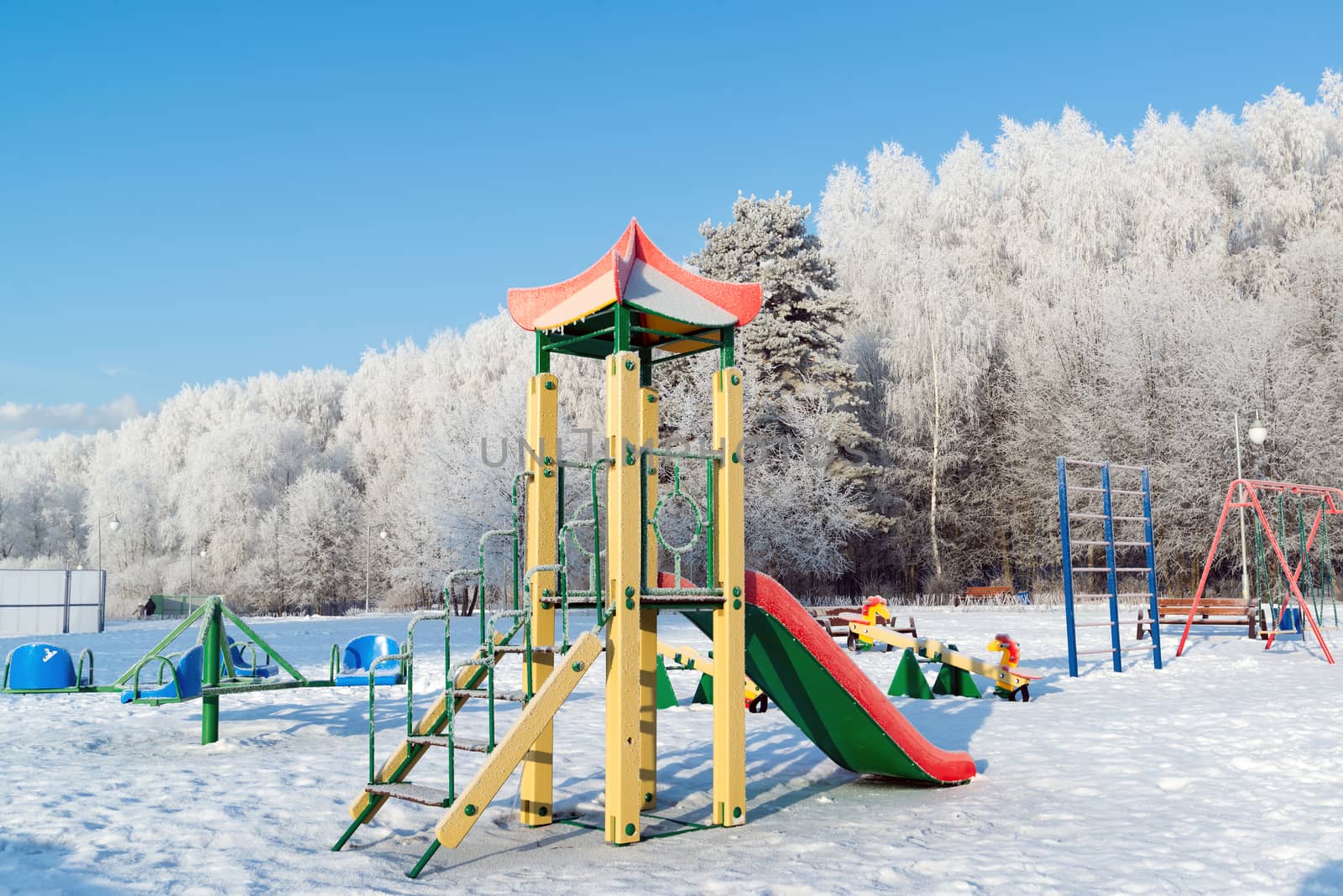 Playground structure outdoors in winter by olgavolodina