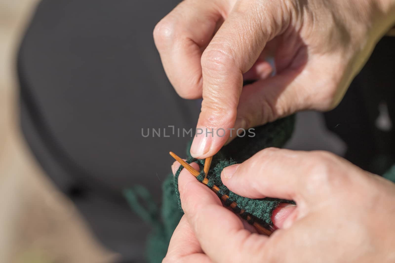 woman knitting green yarn wooden knitting