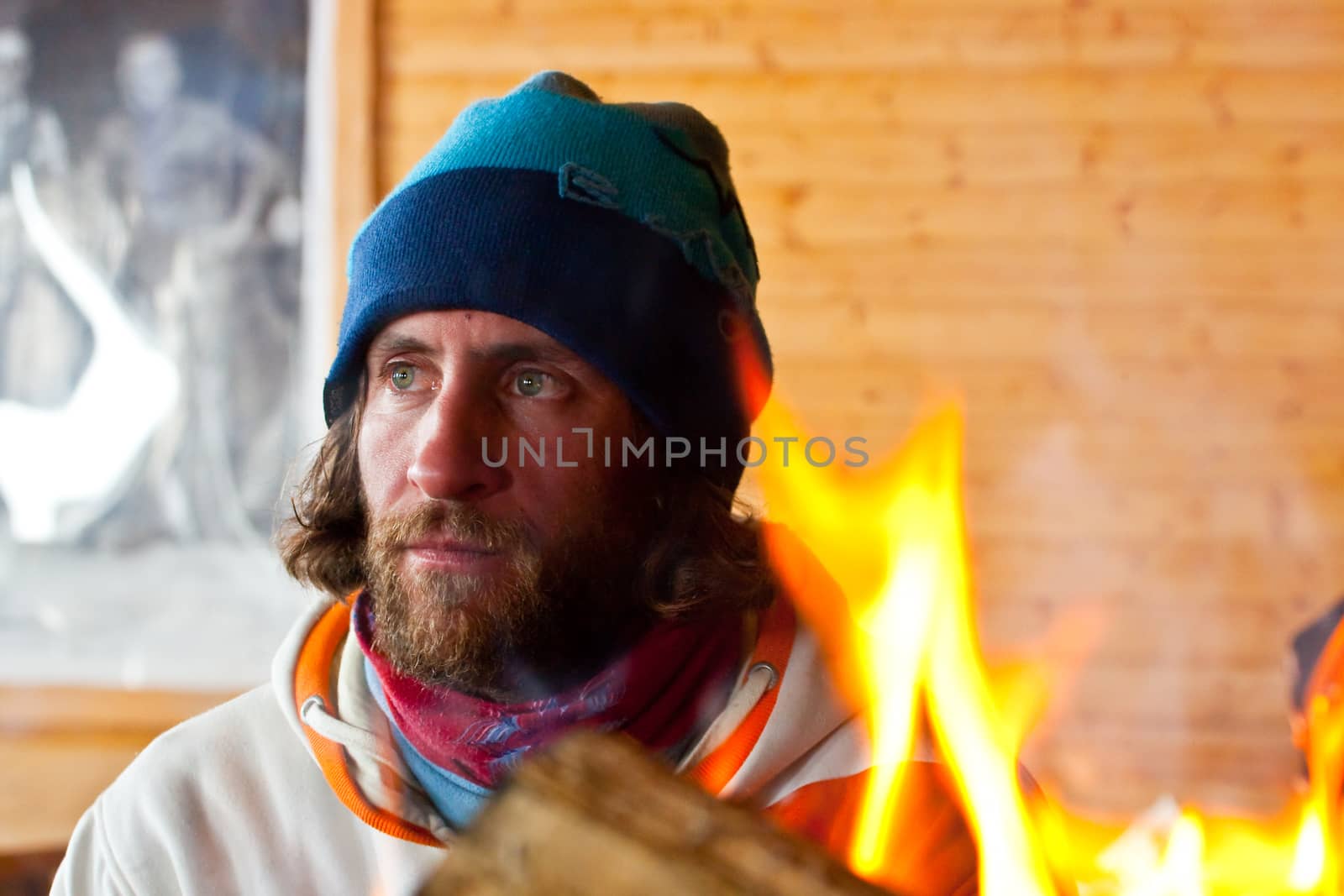 A man with long hair near a fire