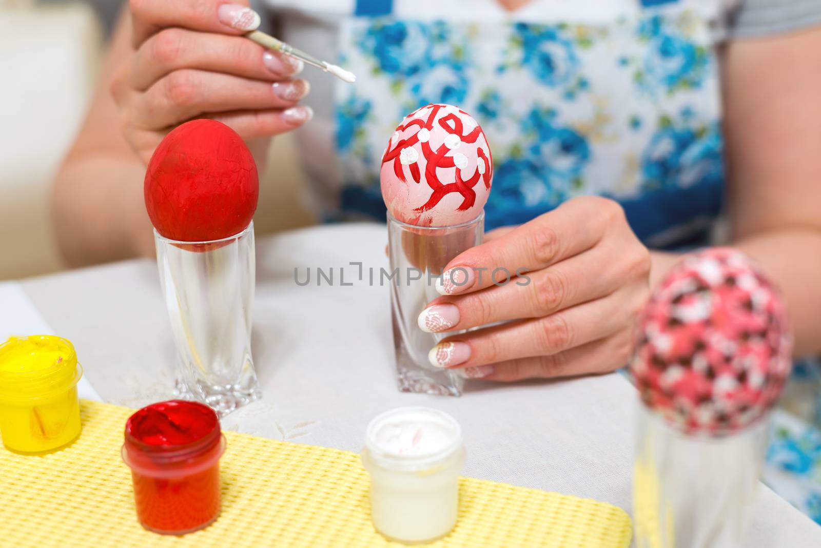 Woman paints the Easter eggs with brush by olgavolodina