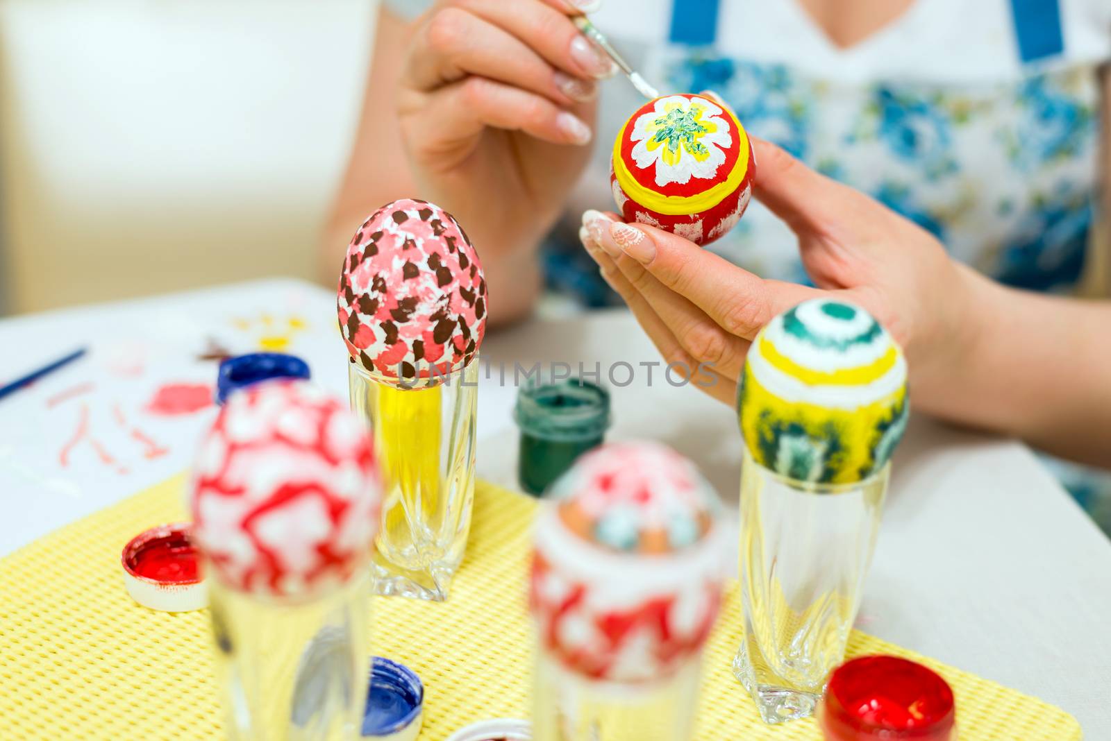 Woman paints the Easter eggs with a brush