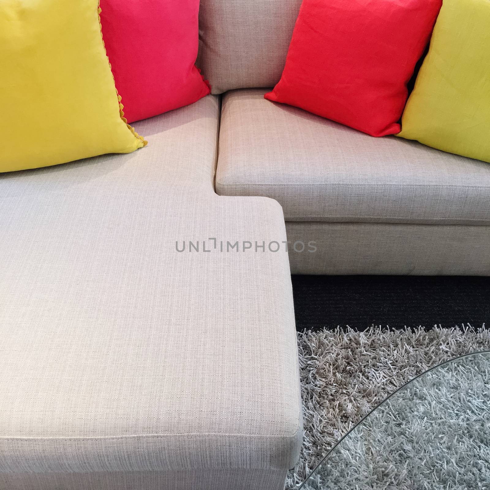 Red and yellow cushions on gray corner sofa by anikasalsera