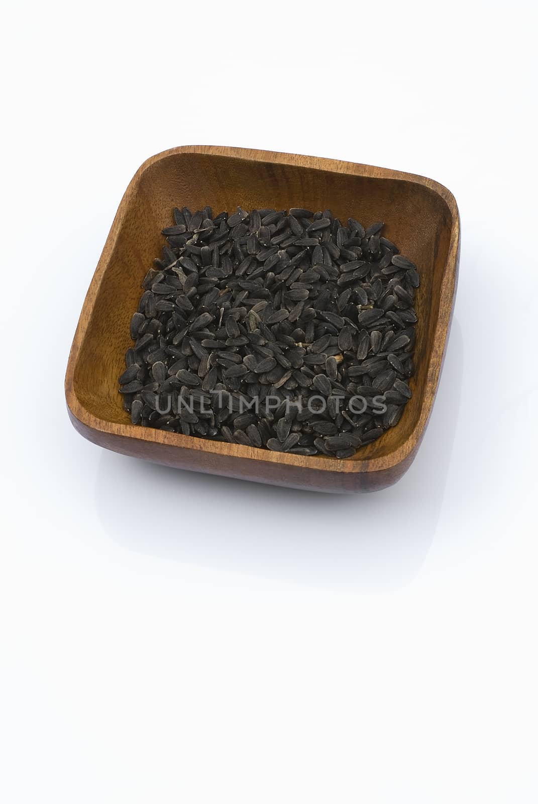 Sunflower seeds with wooden bowl isolated on white background.
