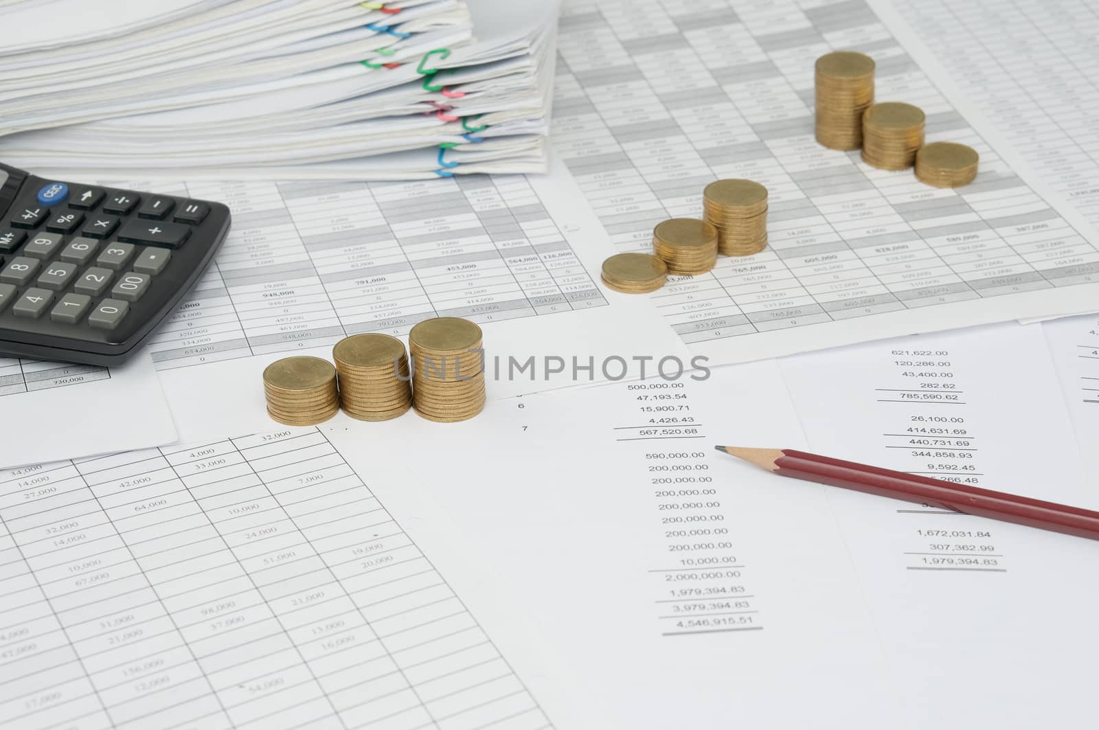 Brown pencil on balance sheet with step of gold coins by eaglesky