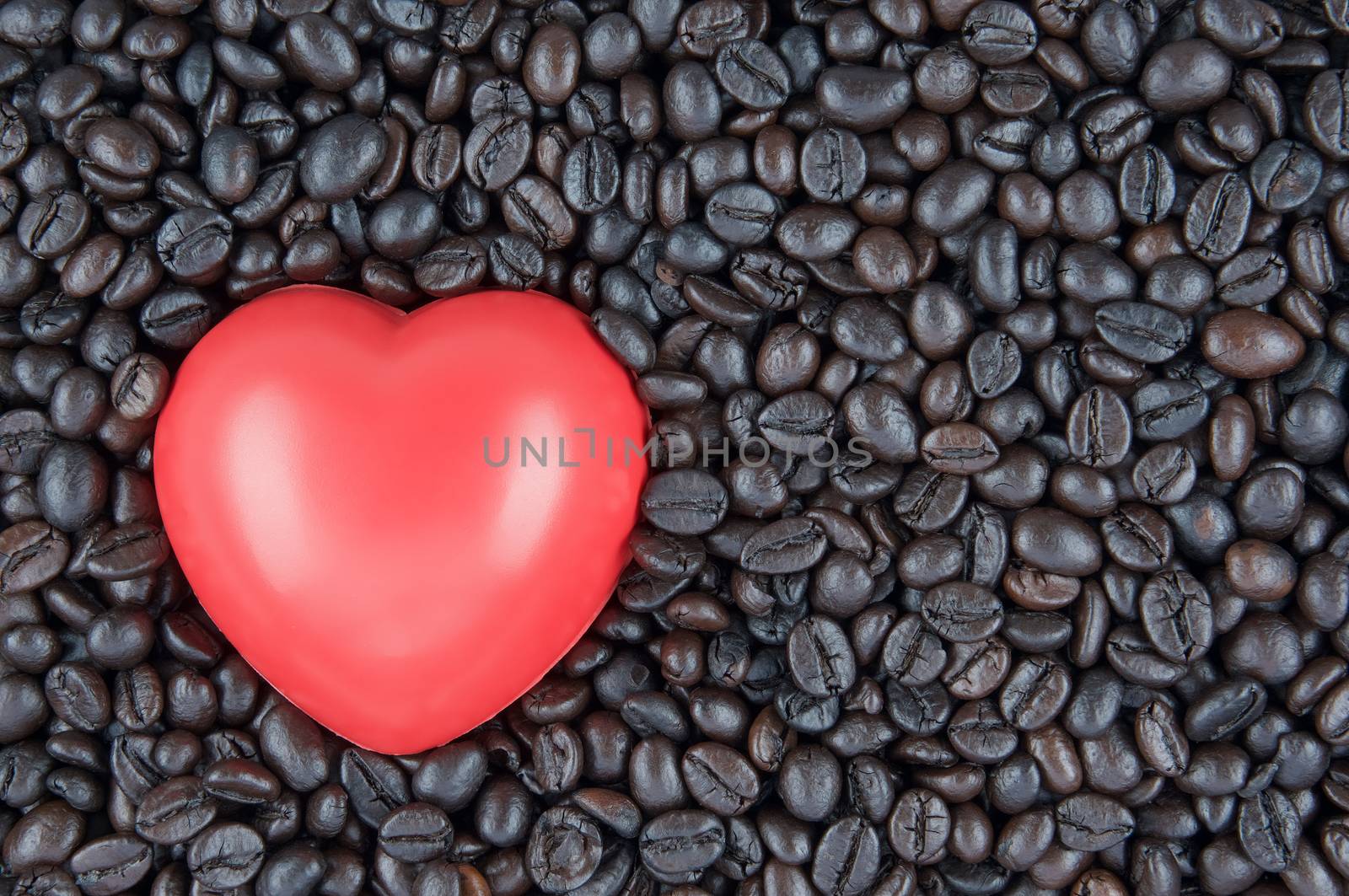 Red heart shape place on black roasted coffee beans by eaglesky