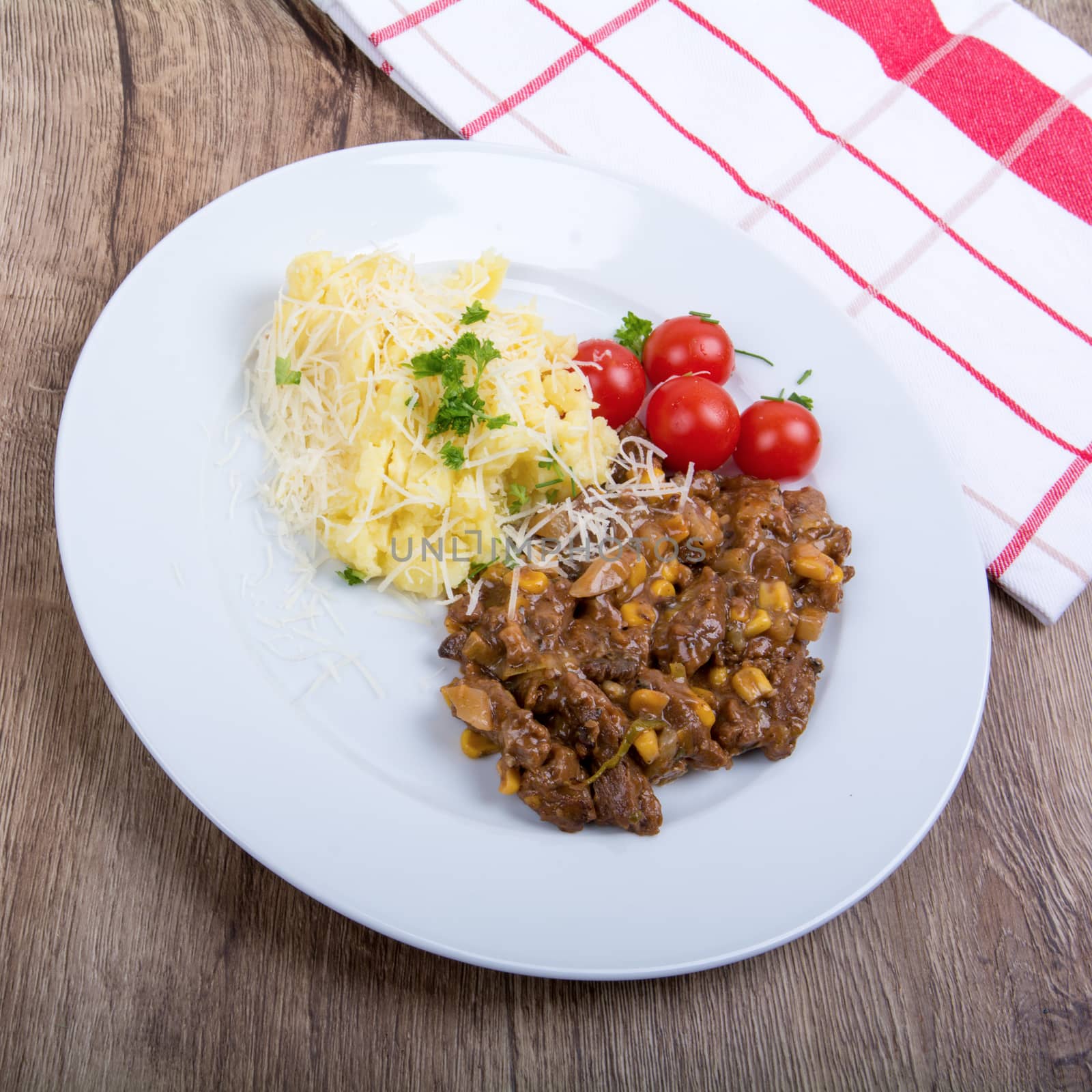 Vegetarian food on a white plate with wooden background