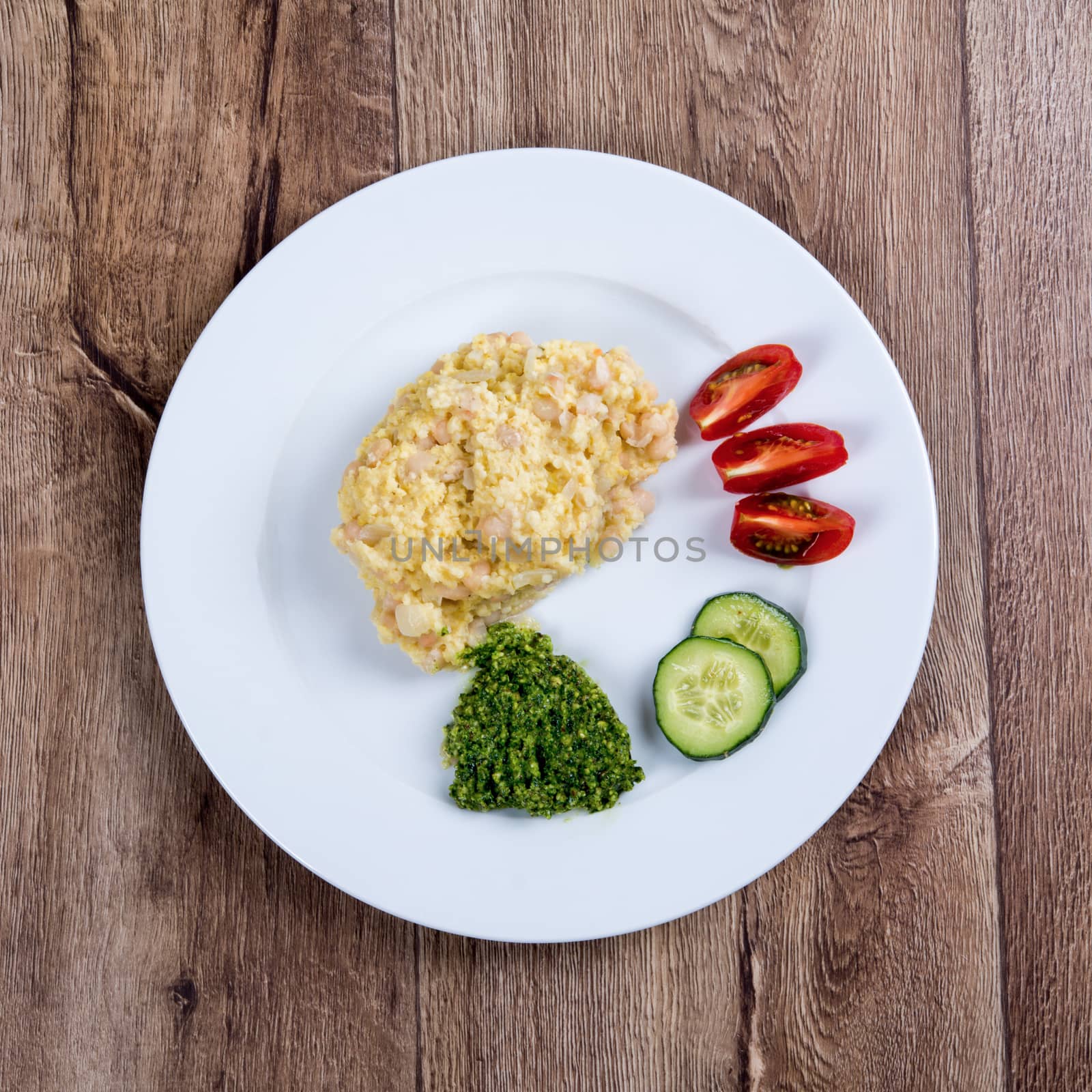 Vegetarian food on a white plate with wooden background