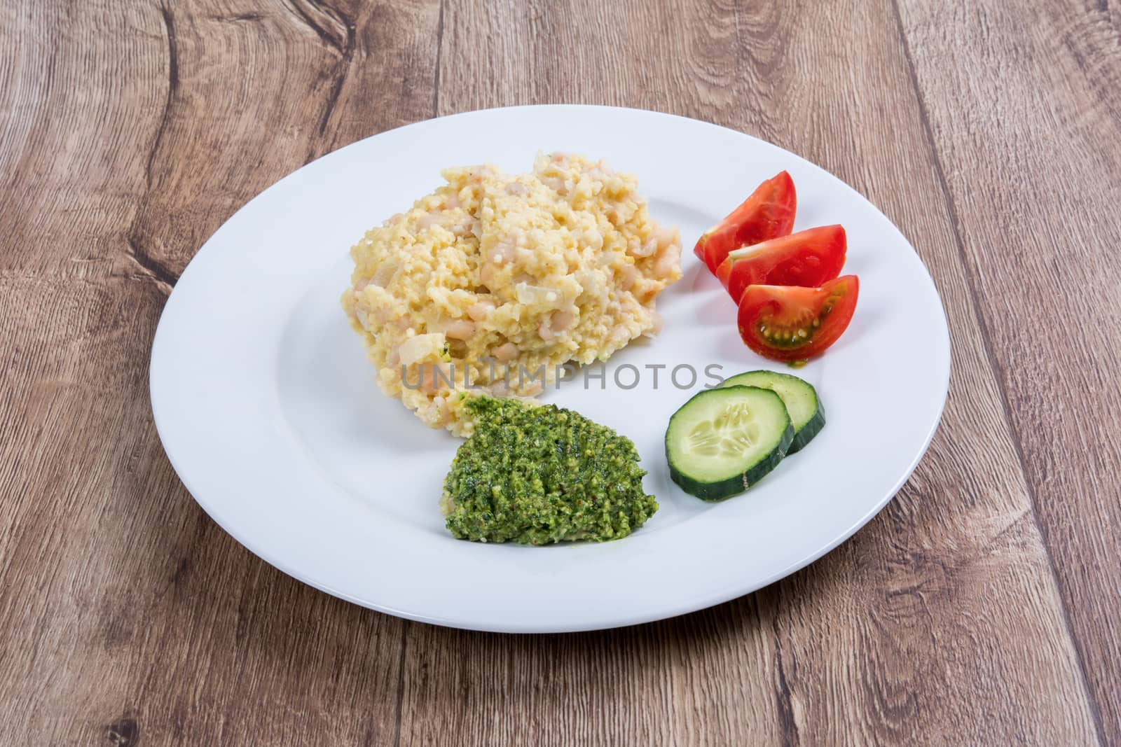 Vegetarian food on a white plate with wooden background